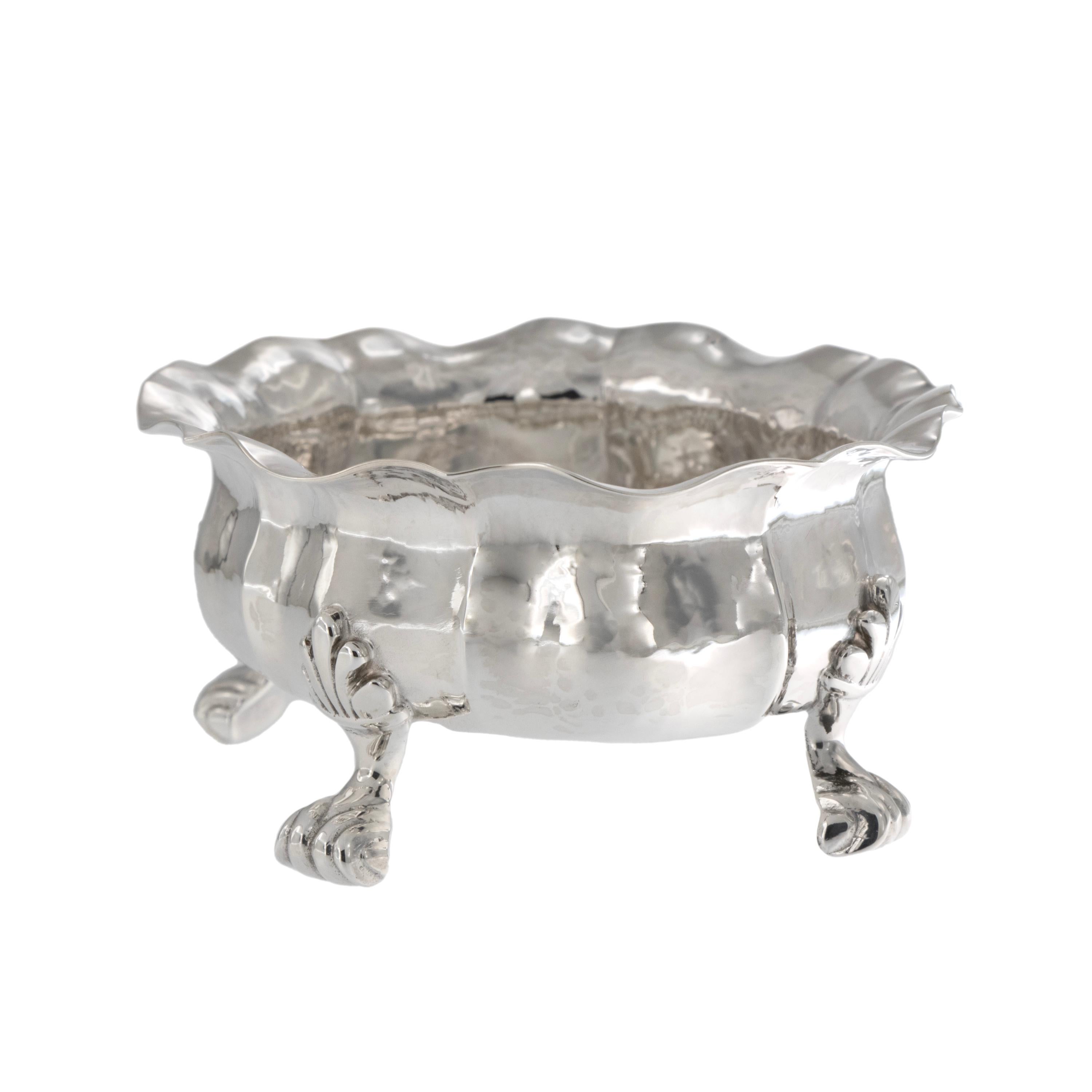 Famed for jewelry and silver since the mid-18th century, Buccellati still produces in small workshops with skilled artisans considered the best in Italy. This vintage classical hand-hammered sterling silver footed bowl with spoon was made by