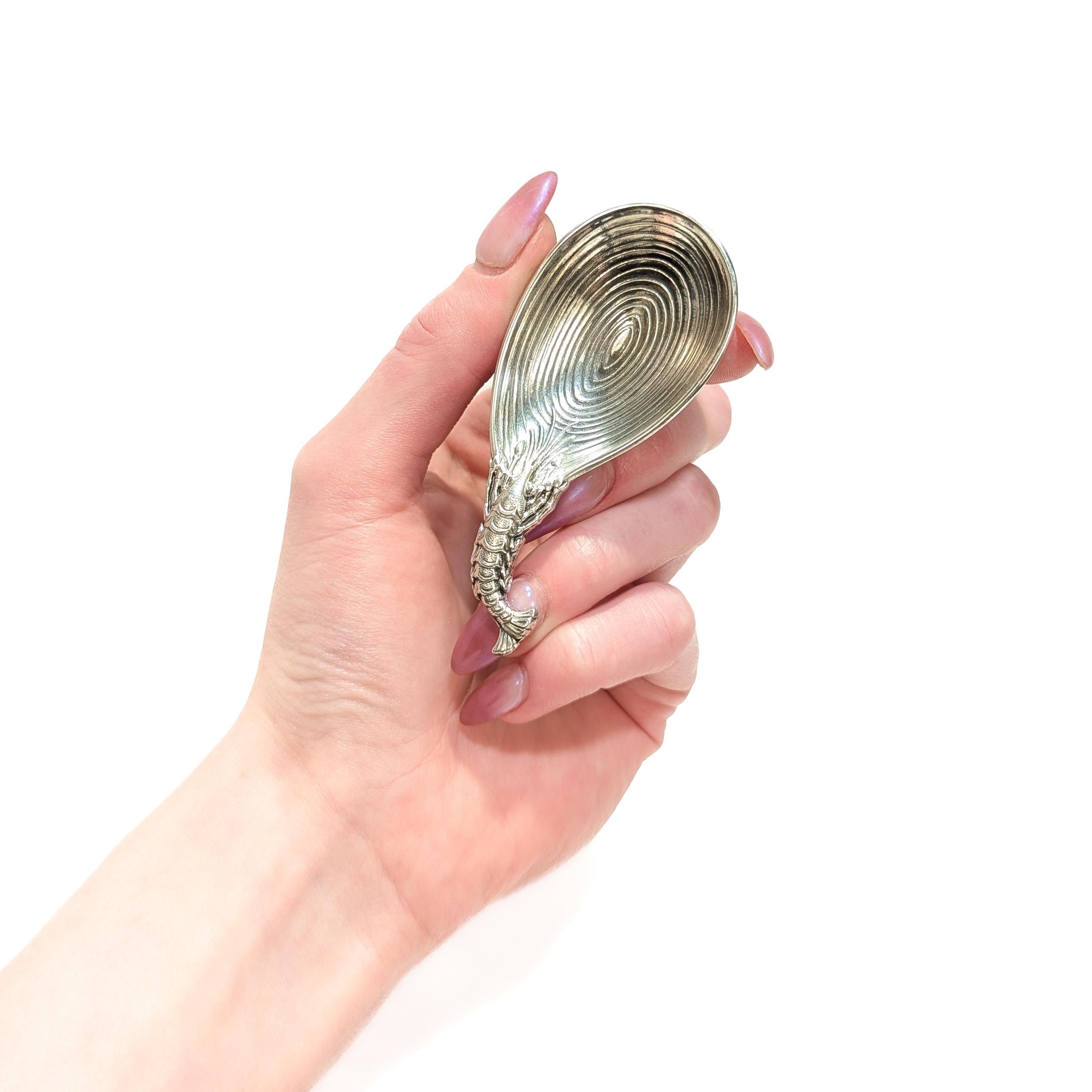 A fine signed Italian silver tea caddy spoon.

By Buccellati.

In sterling silver. 

The bowl engraved with concentric ovals like a shell and the handle in the form of a lobster.

Fully marked to the base.

Simply a wonderful piece by