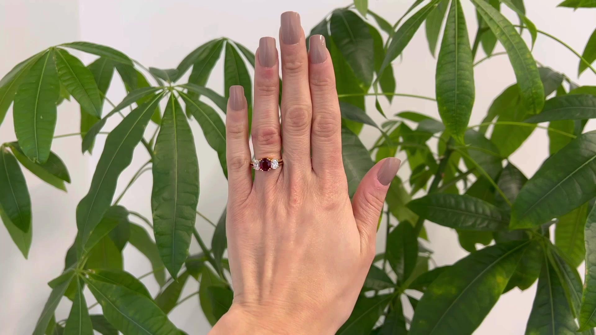 One Vintage Bucherer GIA Thailand Ruby Diamond 18 Karat Yellow Gold Three Stone Ring. Featuring one GIA oval mixed cut ruby weighing approximately 1.40 carats, accompanied with GIA #2221764333 stating the ruby is of Thailand origin. Accented by two
