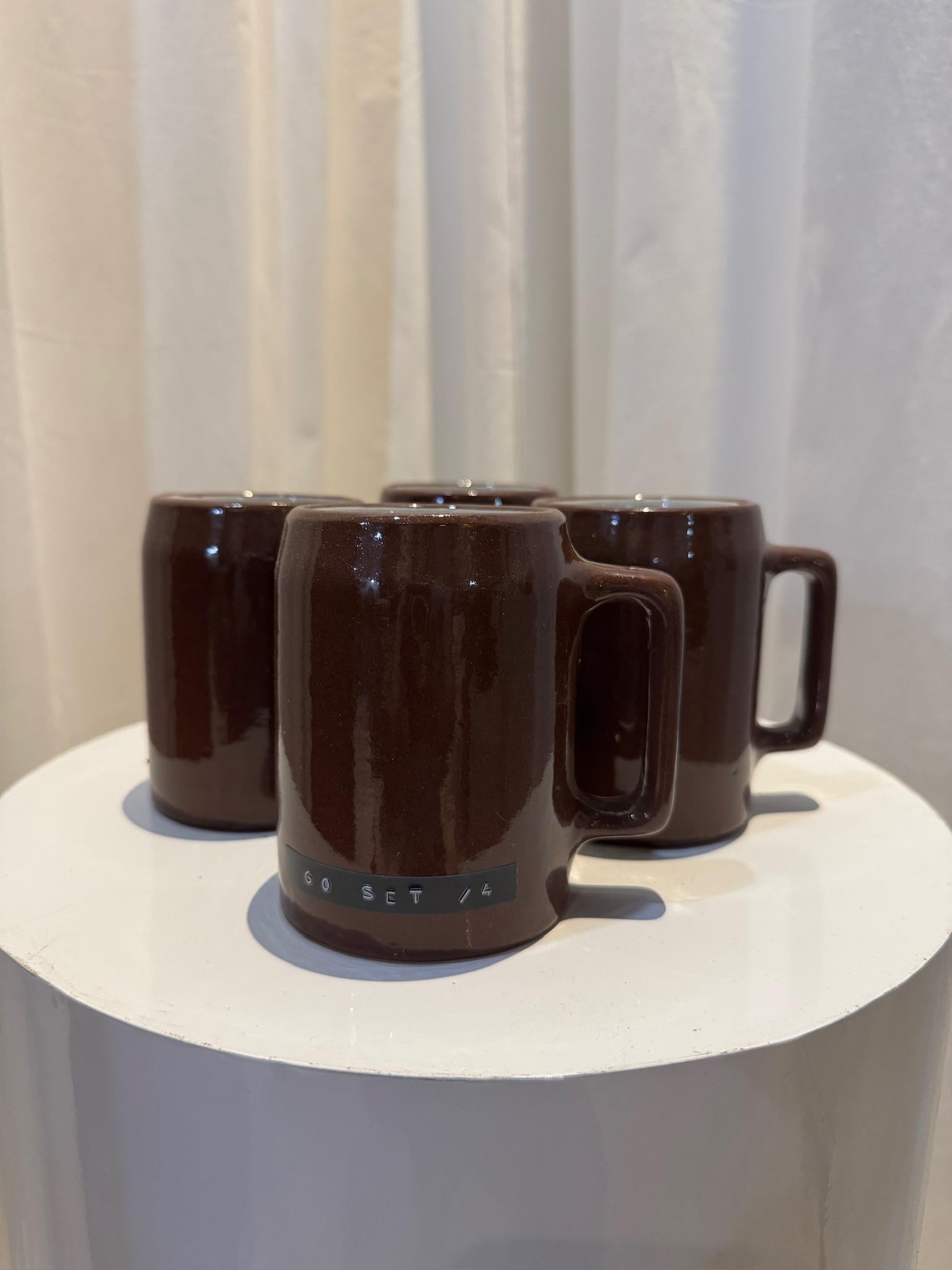 Dale un toque de encanto intemporal y artesanía a tu cocina con este juego de cuatro tazas vintage Buckeye Pottery. Estas preciosas tazas artesanales están hechas de cerámica de barro, con un rico esmalte marrón chocolate en el exterior y una base