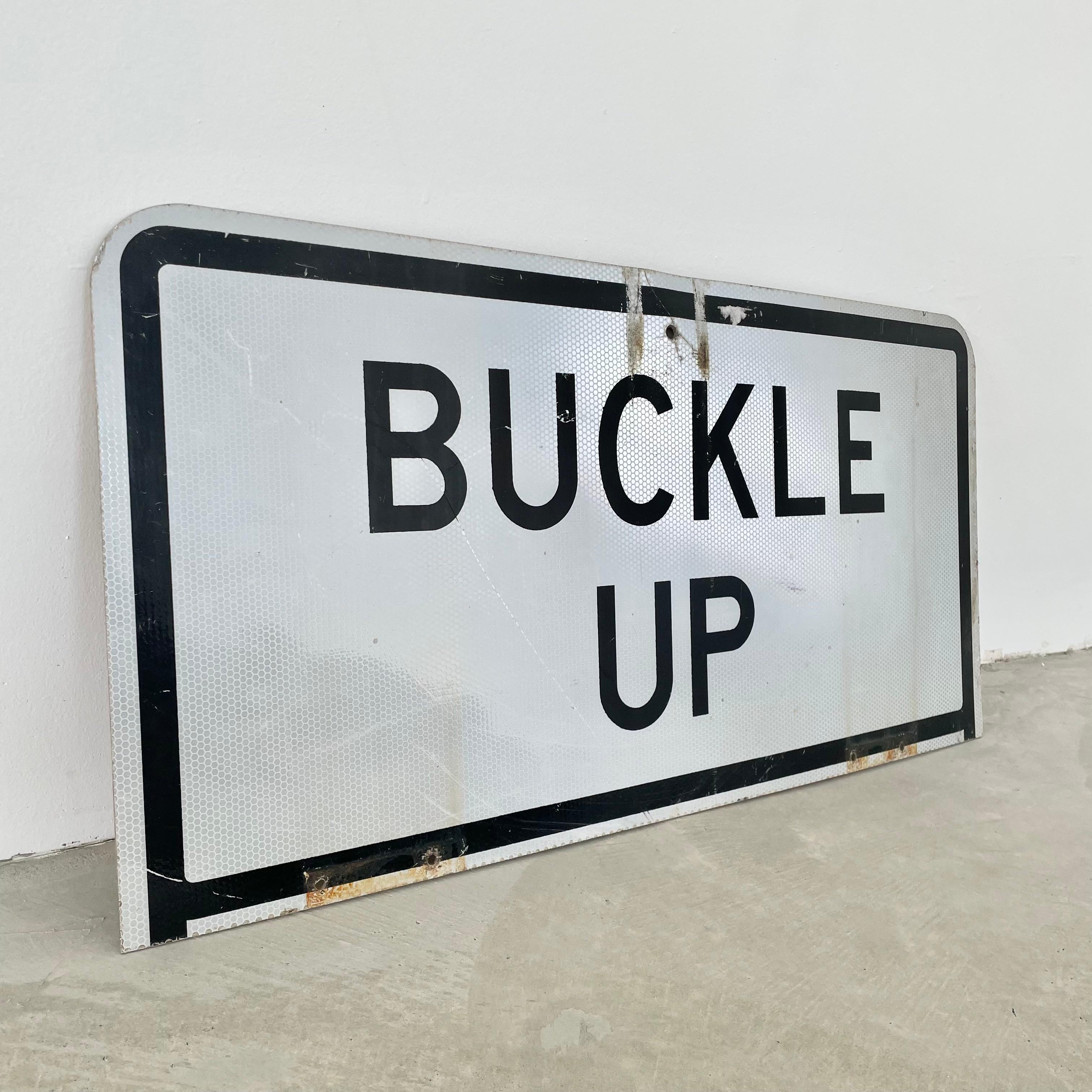 Vintage Buckle Up sign. White reflective background with micro honeycomb pattern. Black lettering and great patina. Reverse side is 