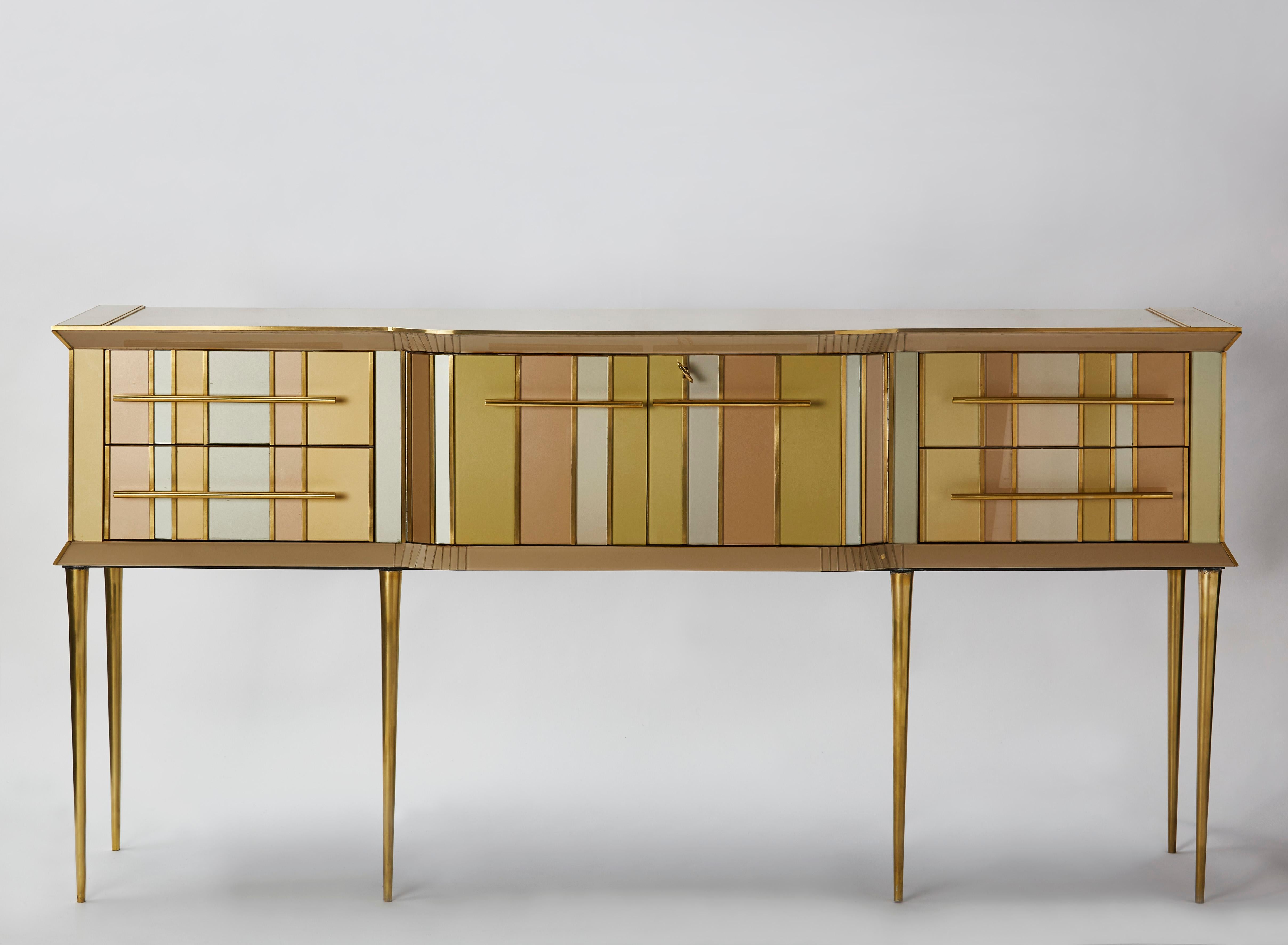 Vintage buffet tainted mirror entirely restored and customized with tainted mirrors and brass inlays. 4 drawers and 2 doors. Brass feet.
Italy, 1980s.