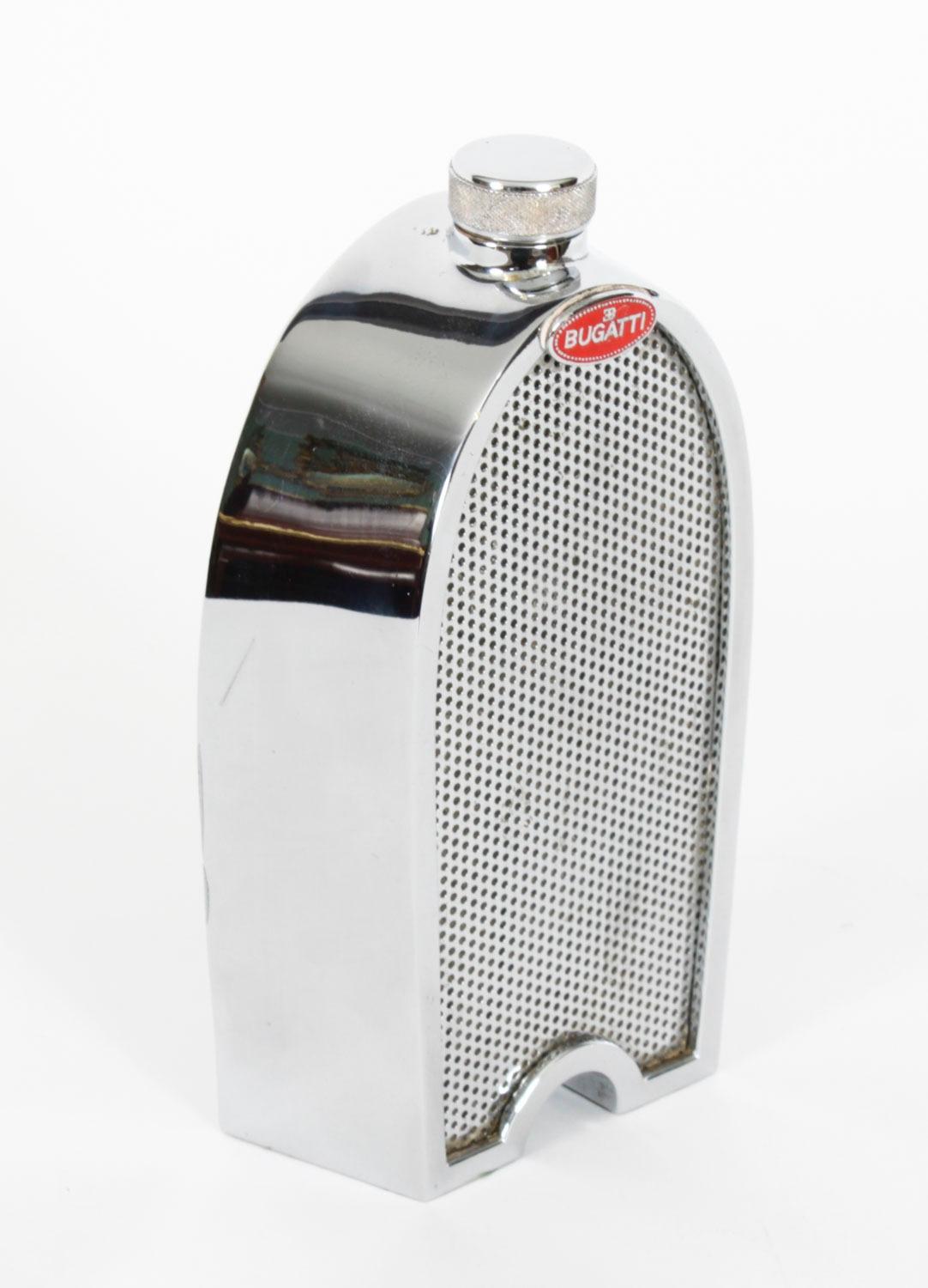 Il s'agit d'une carafe à alcool chromée iconique en forme de radiateur Bugatti, en forme de fer à cheval, avec bouchon, datant de la fin du 20e siècle.

Ceux-ci étaient vendus par des établissements de vente au détail haut de gamme tels que Harrods