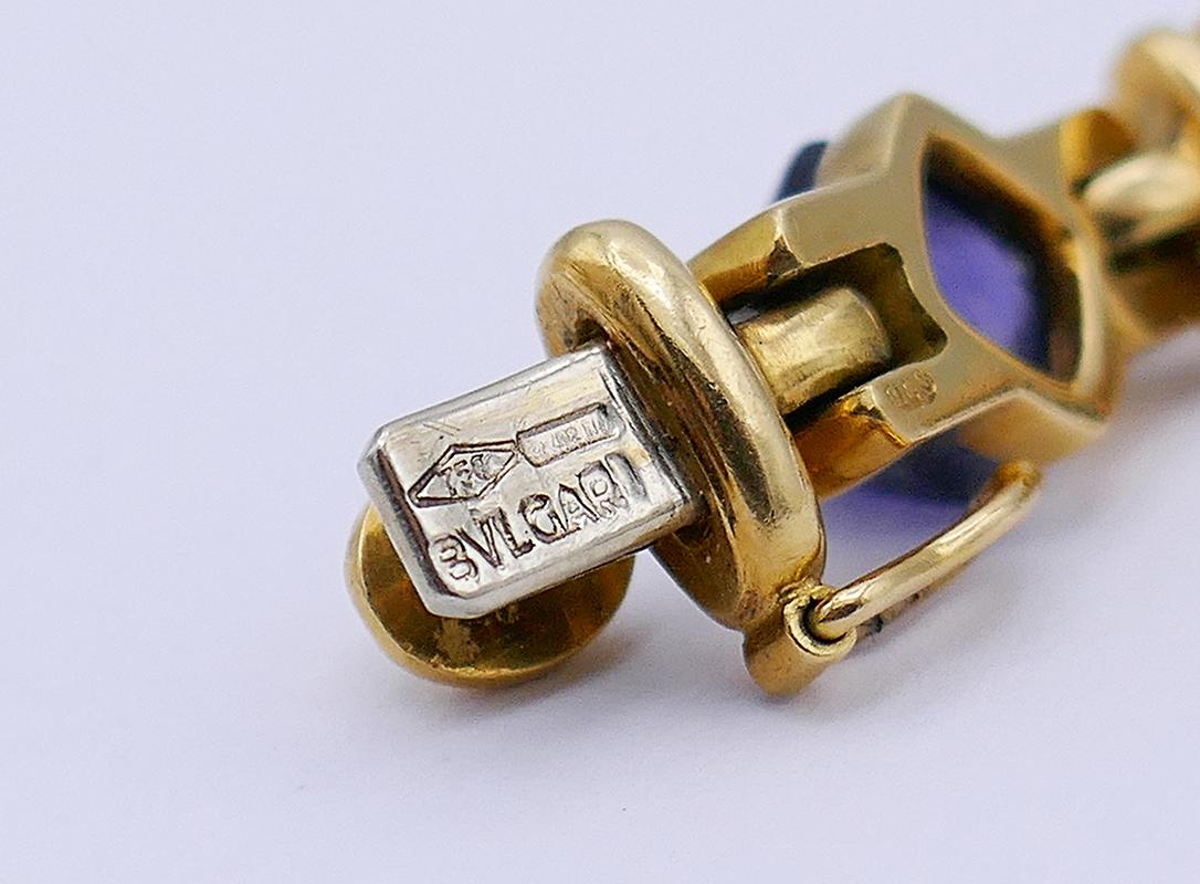 Ein klassisches Bulgari-Armband aus 18 Karat Gelbgold mit farbigen Edelsteinen.
Das Armband besteht aus Goldplättchen, die abwechselnd vertikal und horizontal inszeniert sind. Auf den horizontalen Planken befinden sich mit Lünette und Spannung
