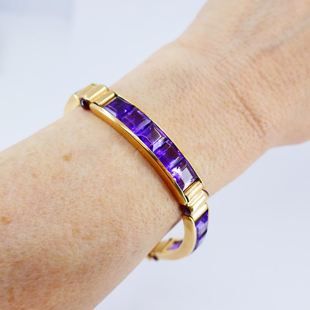	An amazing vintage Bulgari 18k gold bracelet featuring gorgeous color amethyst.
	This vintage bracelet has four amethyst sections connected by gold cylindrical elements. The top and bottom of these elements are accented with the rubellites. The