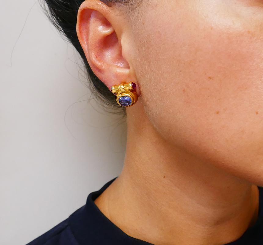          A small but mighty pair of clip-on vintage Bulgari earrings, made of 18 karat yellow gold, featuring sapphire and ruby.
	These Bulgari gold earrings were certainly inspired by ancient Roman architecture. They are crafted as little drops