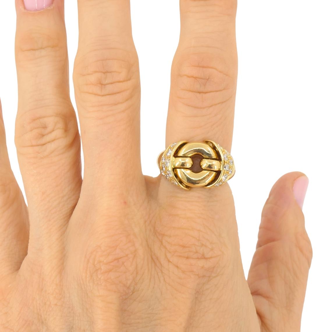 This vintage Bulgari ring is an 18k yellow gold ring featuring a geometrical motif accented with pavé-set diamonds.  The design centers on an interlocking circular element. Its rounded form gives the ring a great dimensional look. The band is smooth