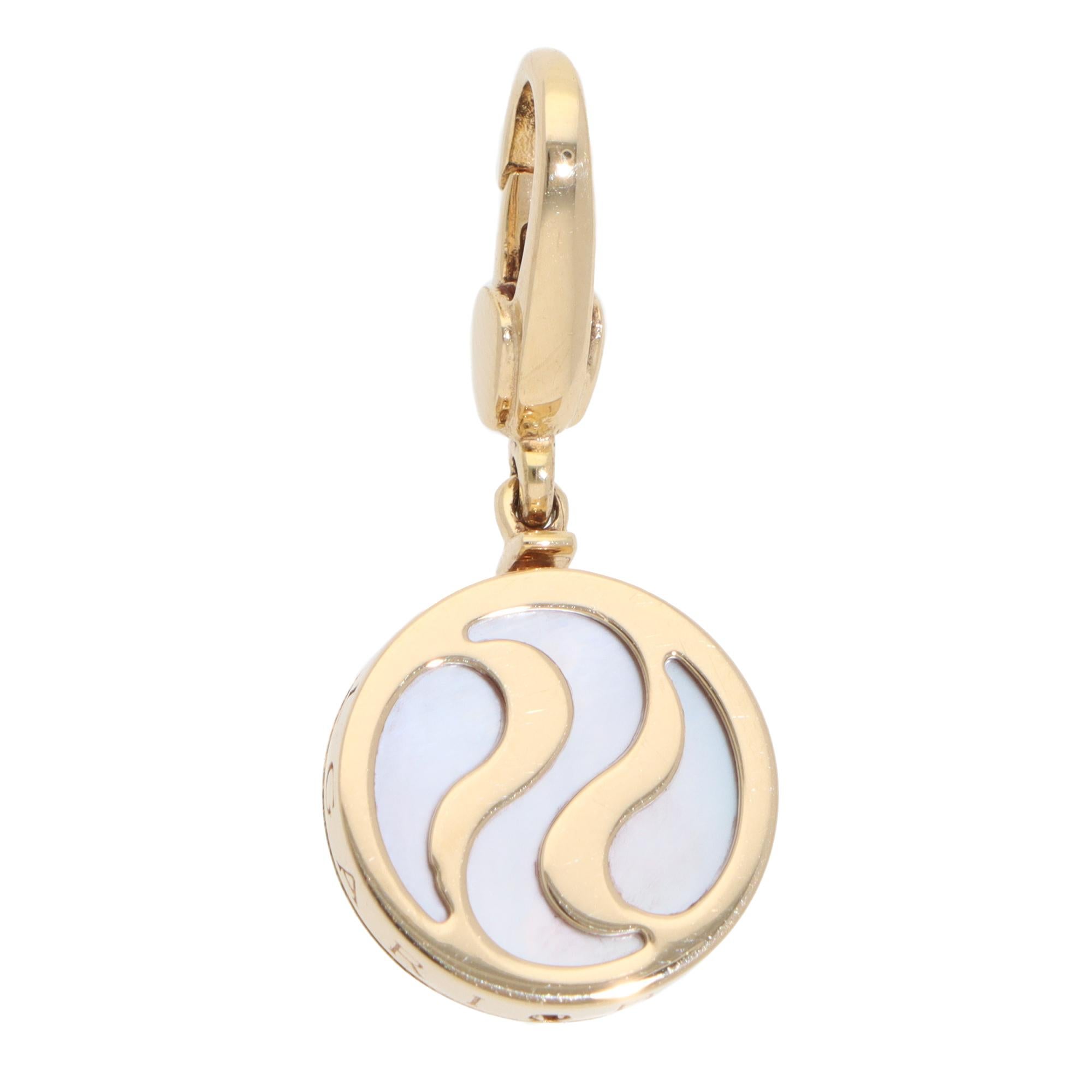A beautiful vintage Bulgari mother-of-pearl Optical Illusion pendant set in 18k yellow gold.

From Bulgari's discontinued collection, the pendant is composed of a round yellow gold piece with white mother-of-pearl. The side is engraved with the