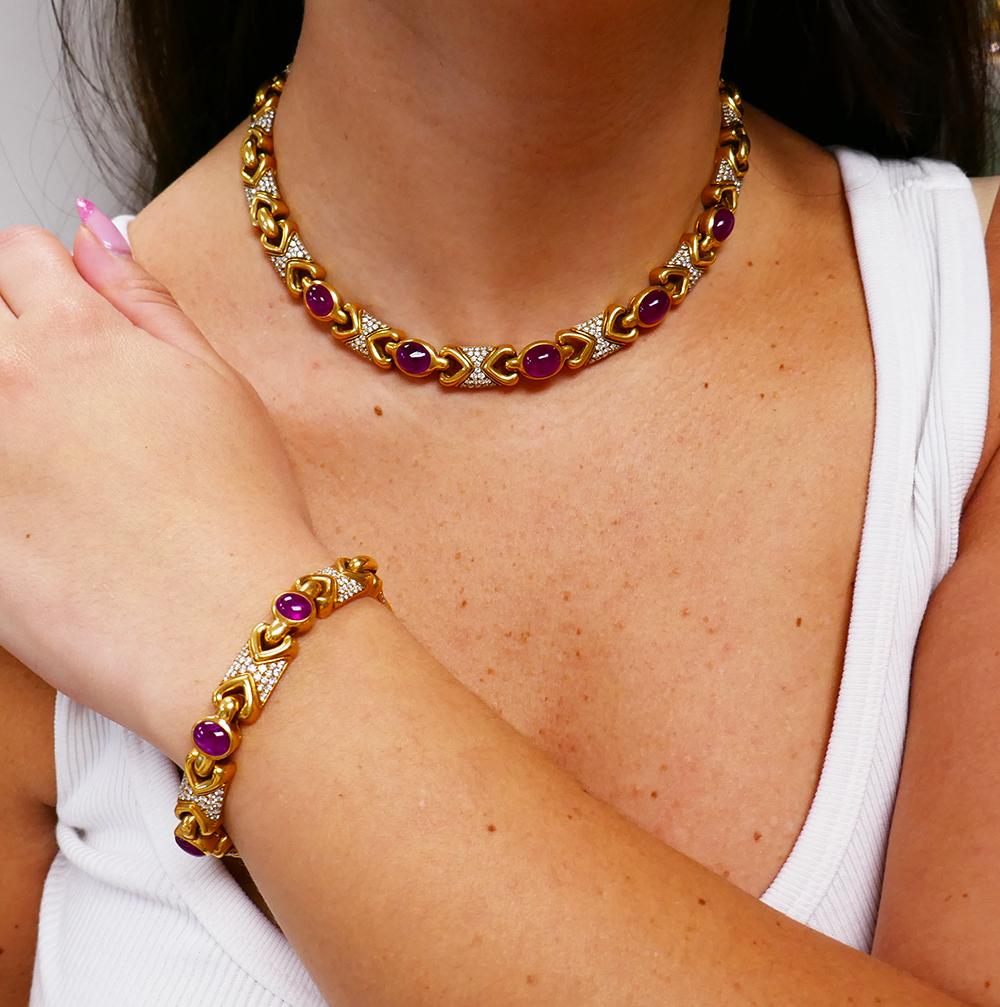 A classic vintage Bulgari set from Doppio Cuore collection, made of 18 karat gold, ruby and diamond.  
The vintage set consists of a necklace and a bracelet. Each piece carries cabochon rubies, three rubies for the bracelet and five for the