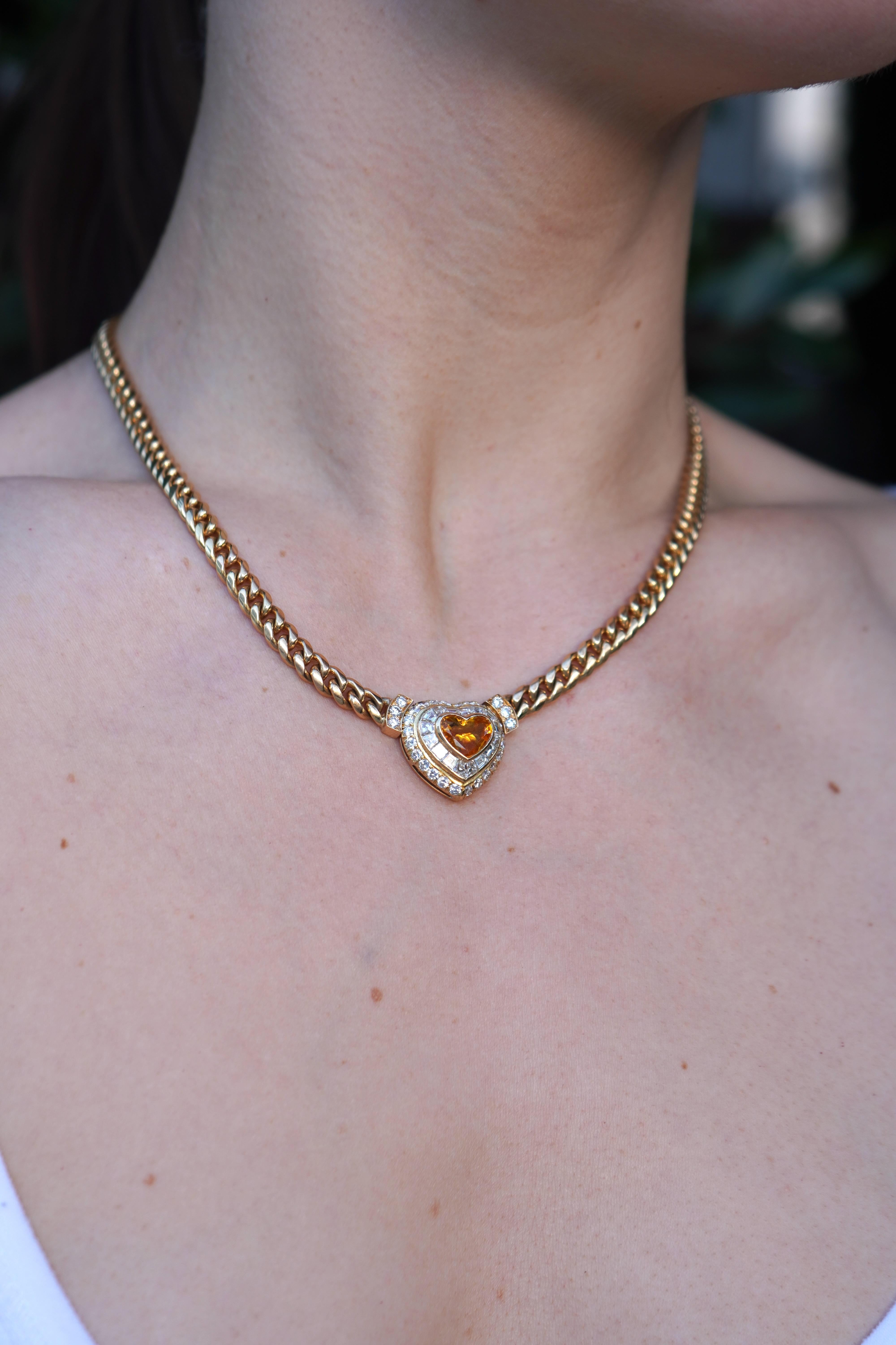 Questa collana vintage di Bvlgari, realizzata in oro 18 carati, presenta un design audace ed elegante. Il pezzo forte è uno zaffiro giallo arancio da 3,00 carati con taglio a cuore, incastonato in un castone che ne mette in risalto la tonalità