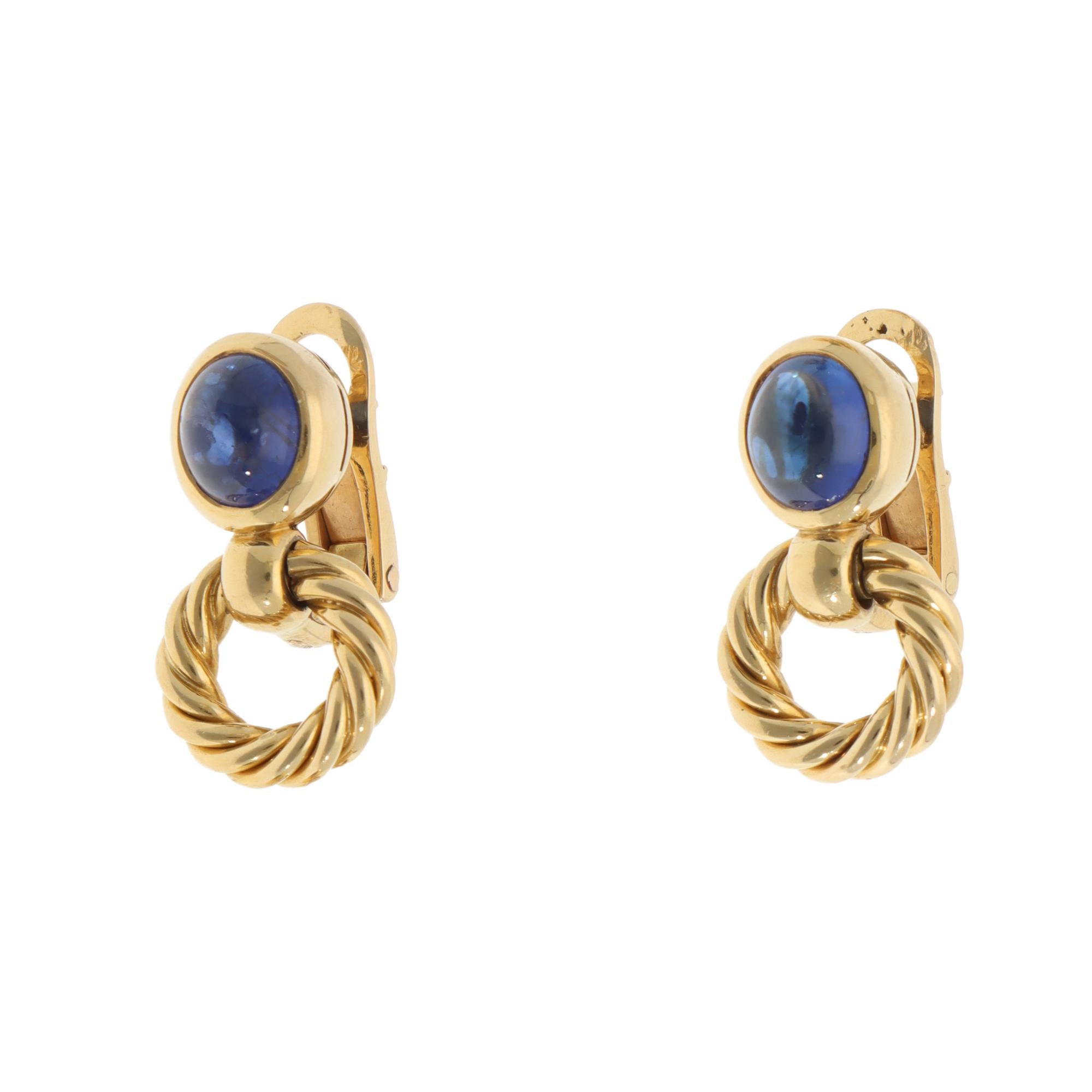 A beautiful pair of vintage Bulgari sapphire earrings set in 18k yellow gold.

From the discontinued Bulgari collection, each earring is firstly composed of an oval cabochon sapphire securely set in a bezel setting. Ascending from this stud aspect