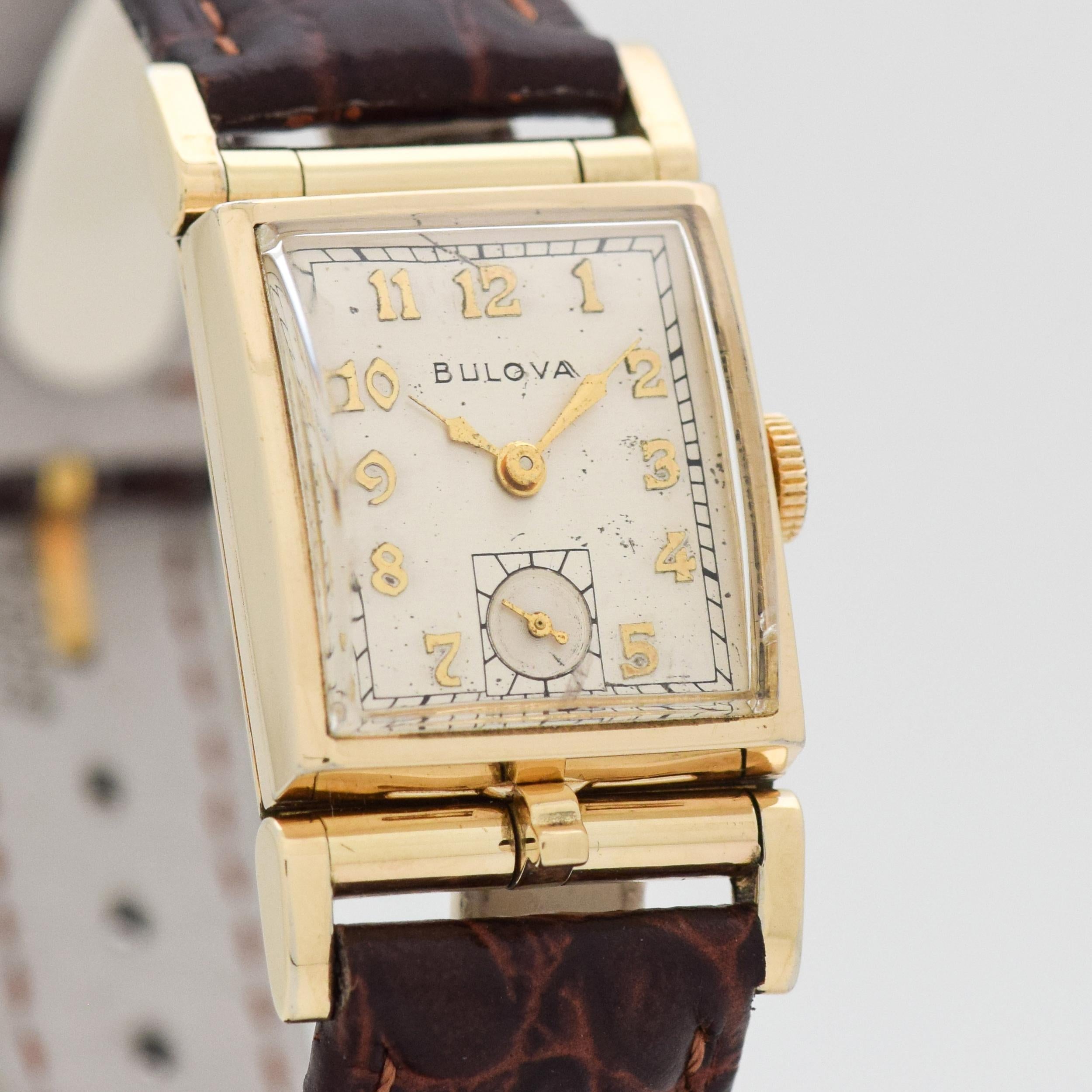 1950 Vintage Bulova 10k Yellow Gold Filled watch with Unique Separate Concealed Locket for Inclusion of Photo with Original Silver Dial with Applied Gold Color Arabic Numbers. Triple Signed. Suitable for a Man or a Woman. 21mm x 40mm lug to lug