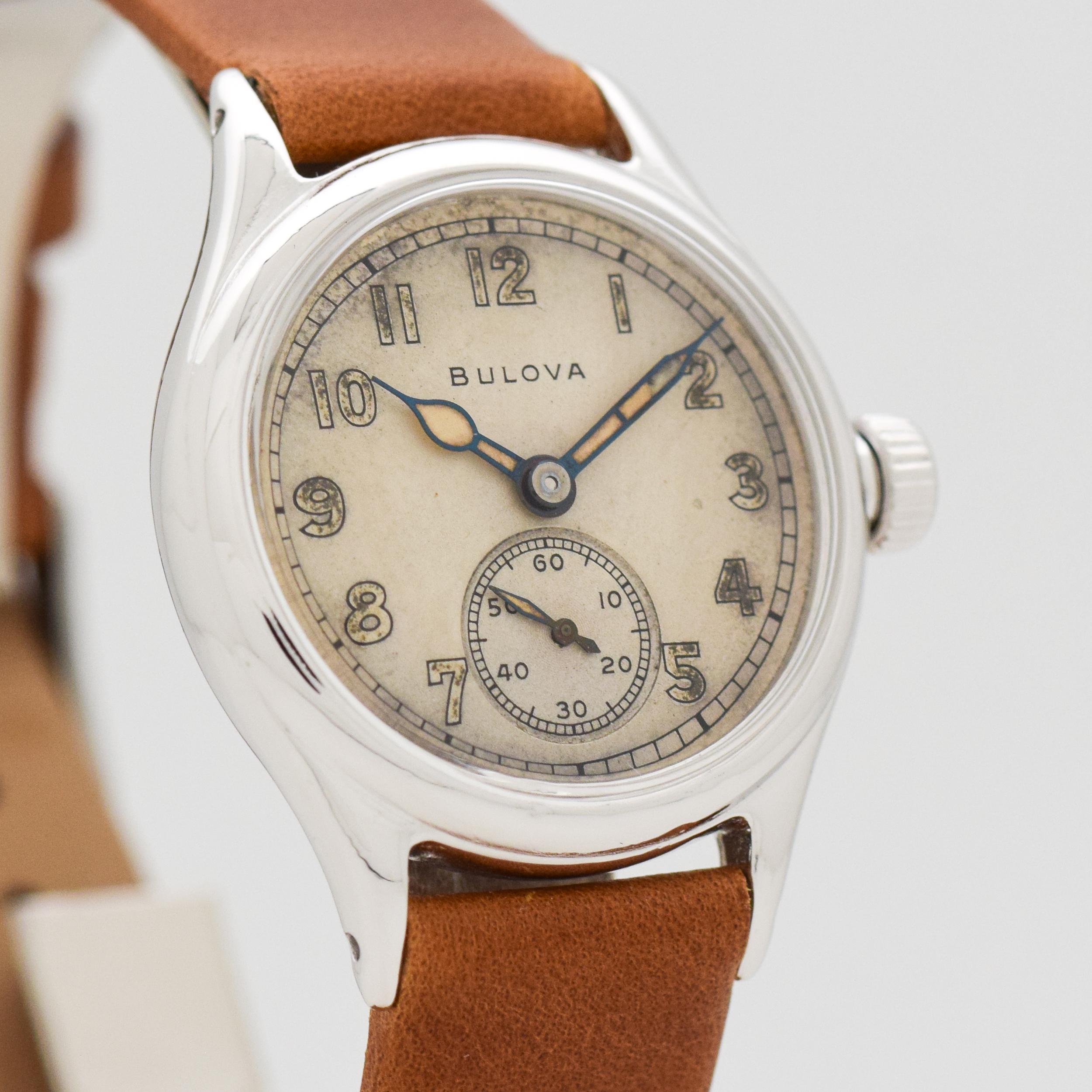 1944 Vintage Bulova WWII Military Chrome watch with Original Silver Dial with Light Brown Luminous Arabic Numbers. 32mm x 39mm lug to lug (1.26 in. x 1.54 in.) - 15 jewel, manual caliber movement. Equipped with a Genuine Leather Brown Watch Strap.