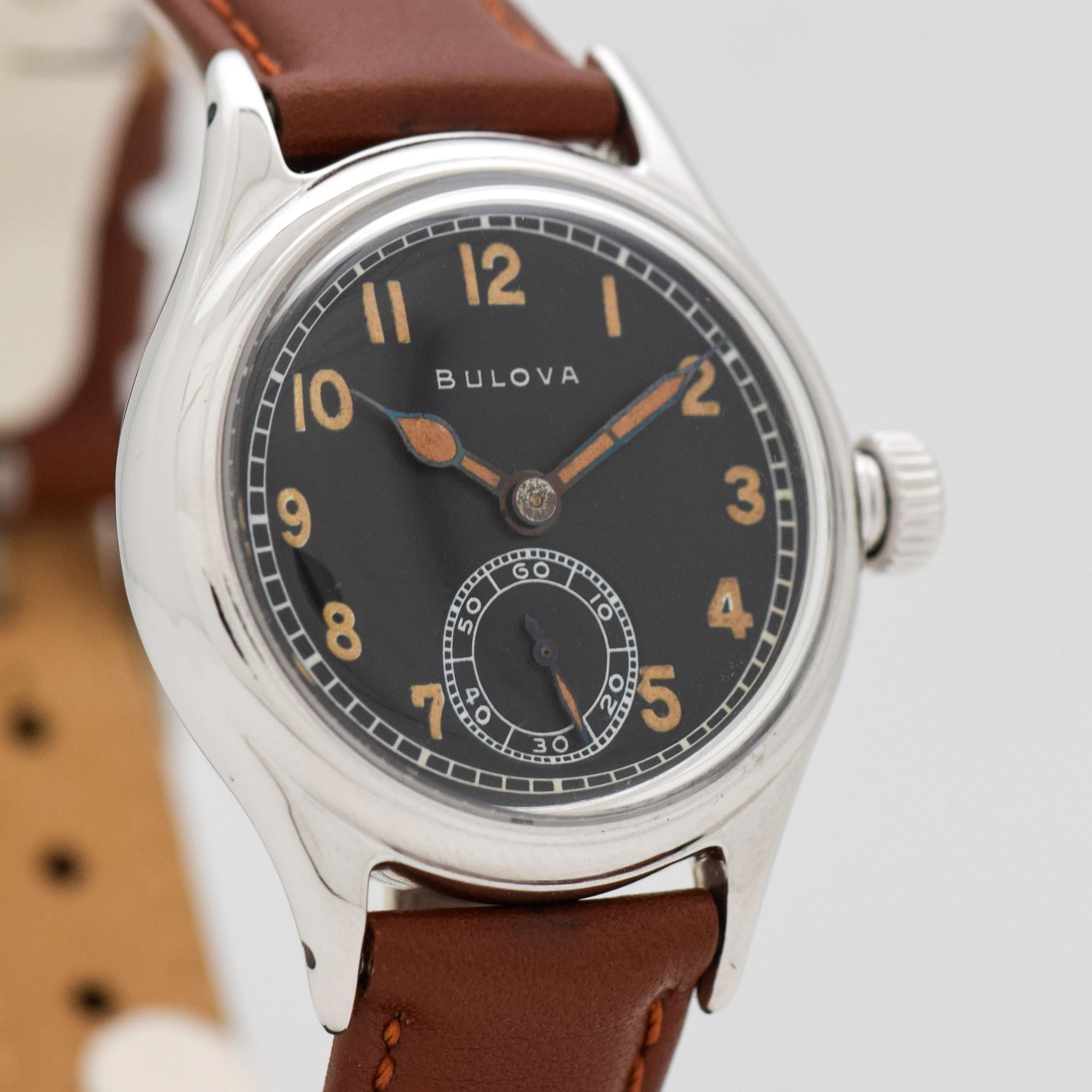 1944 Vintage Bulova WWII Military Chrome watch with Original Black Dial with Light Brown Luminous Arabic Numbers. Case sized, 32mm x 39mm lug to lug (1.26 in. x 1.54 in.) - Powered by a 15-jewel, manual caliber movement. Triple Signed.