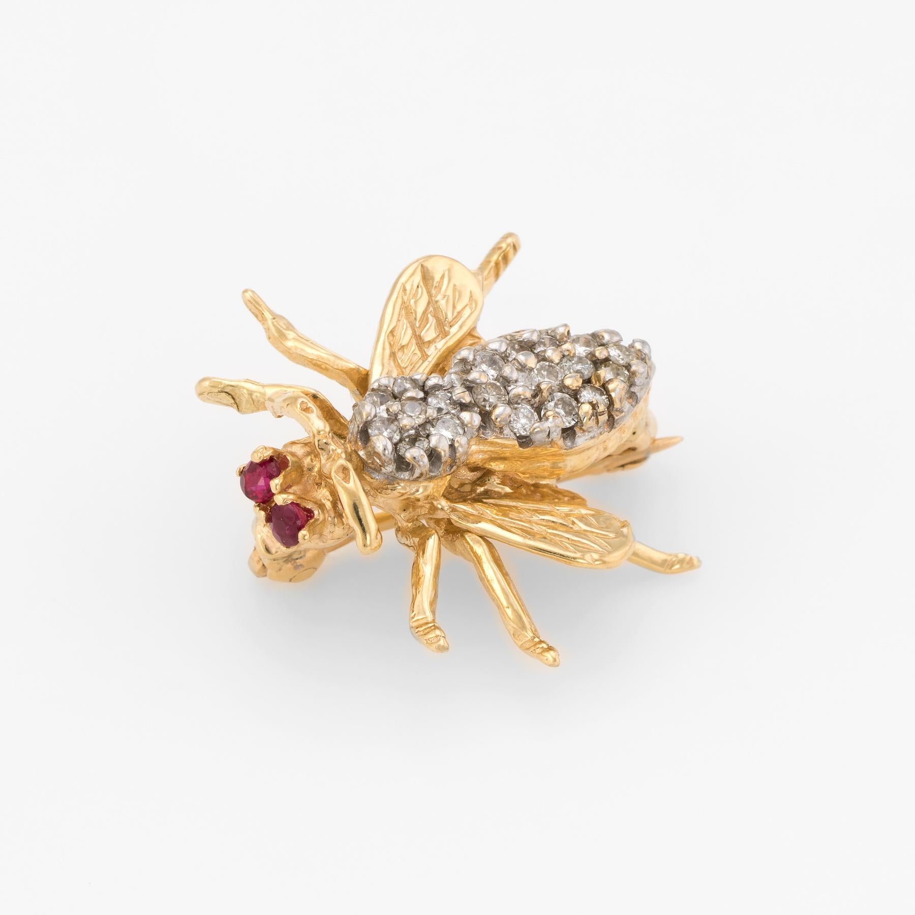 Charming bee brooch, crafted in 14 karat yellow gold. 

20 round brilliant cut diamonds total an estimated 0.15 carats (estimated at I color and I1 clarity). Two estimated 0.02 carat rubies are set into the eyes (0.04 carats total estimated weight).