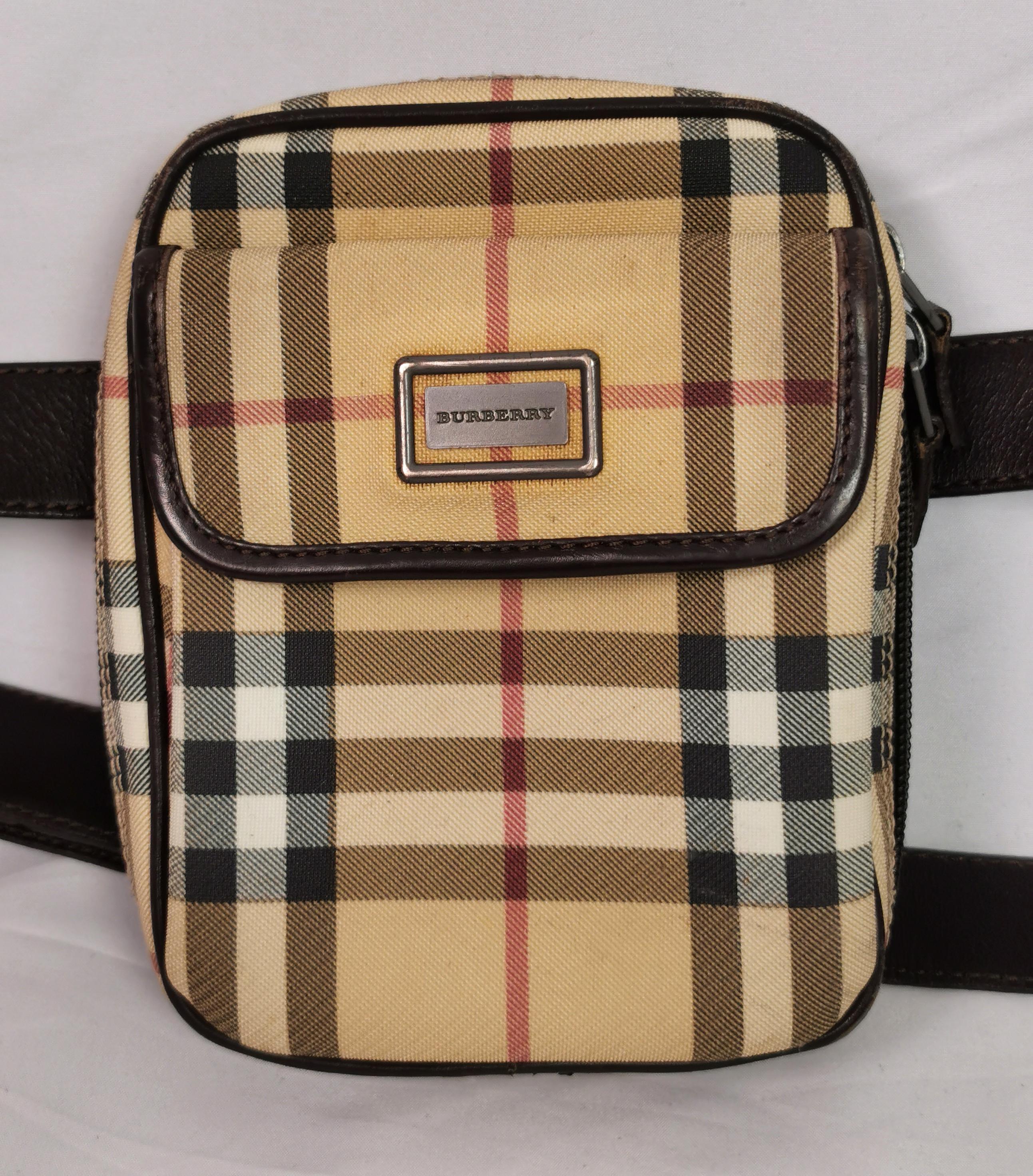 A stylish vintage Burberry belt bag, can be worn around the waist or Crossbody.

It is a small camera shaped bag with a front flap pocket that fastens with a snap fastener.

This is the perfect bag for travel or on the go.

Classic Nova check in a