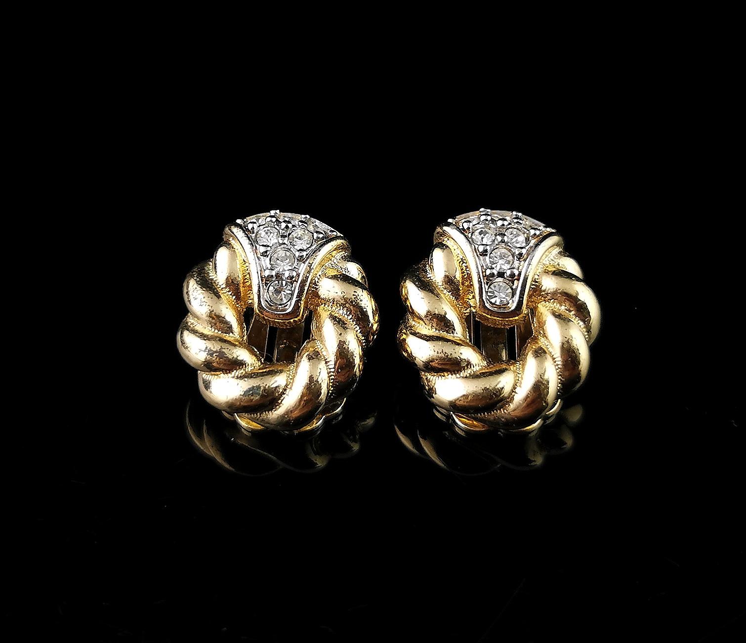 A fantastic pair of vintage Burberry
clip on earrings.

A smaller pair of clip on earrings they have an oval shape with a twist design in rich gold tone metal.

To the top there is a white metal section studded with clear diamante giving a lovely
