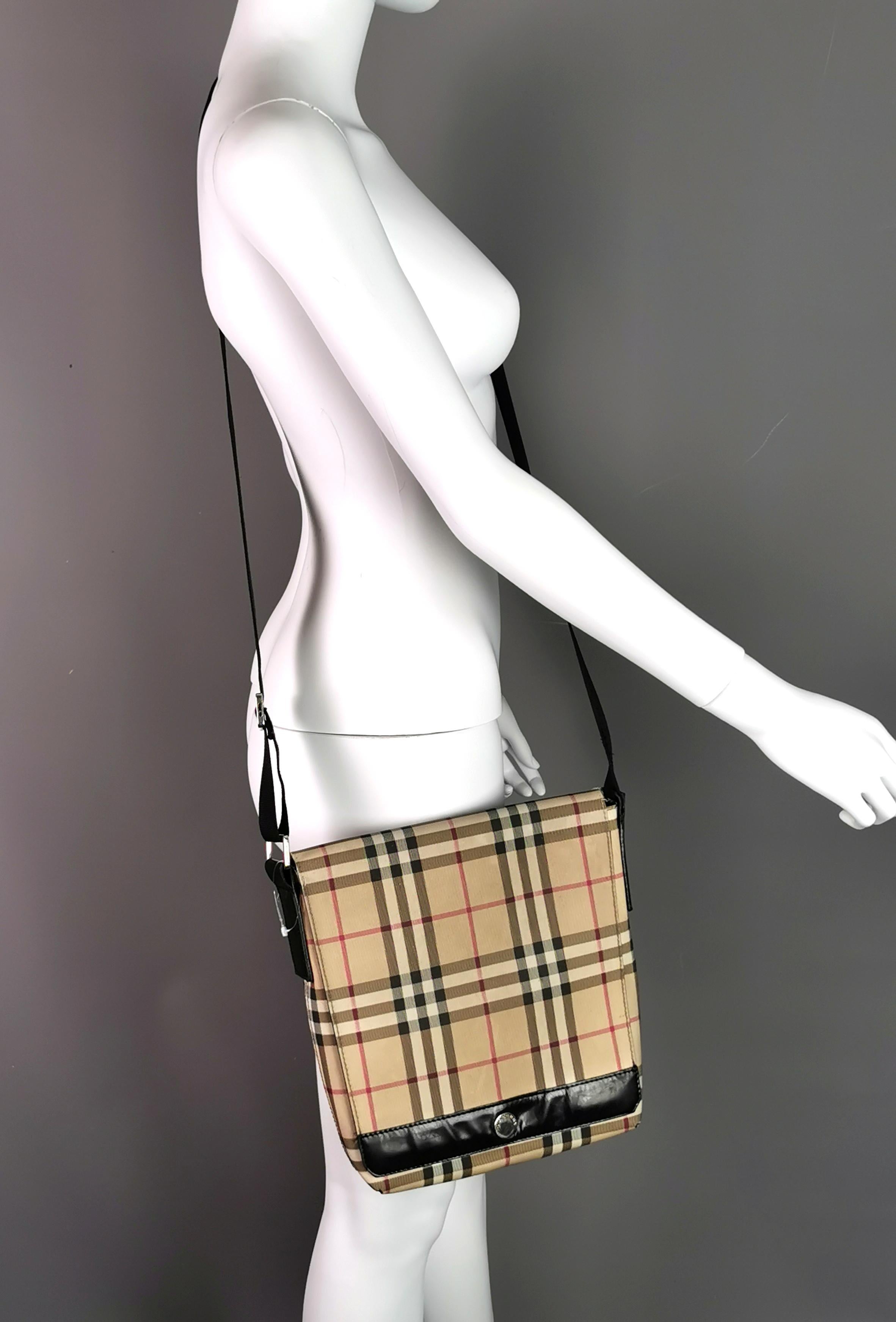 A stylish vintage Burberry Crossbody satchel or messenger type bag, can be worn over the shoulder or Crossbody.

Classic Nova check in a lightly coated canvas.

It has black webbing strap with woven branding and a leather strip to the front near the