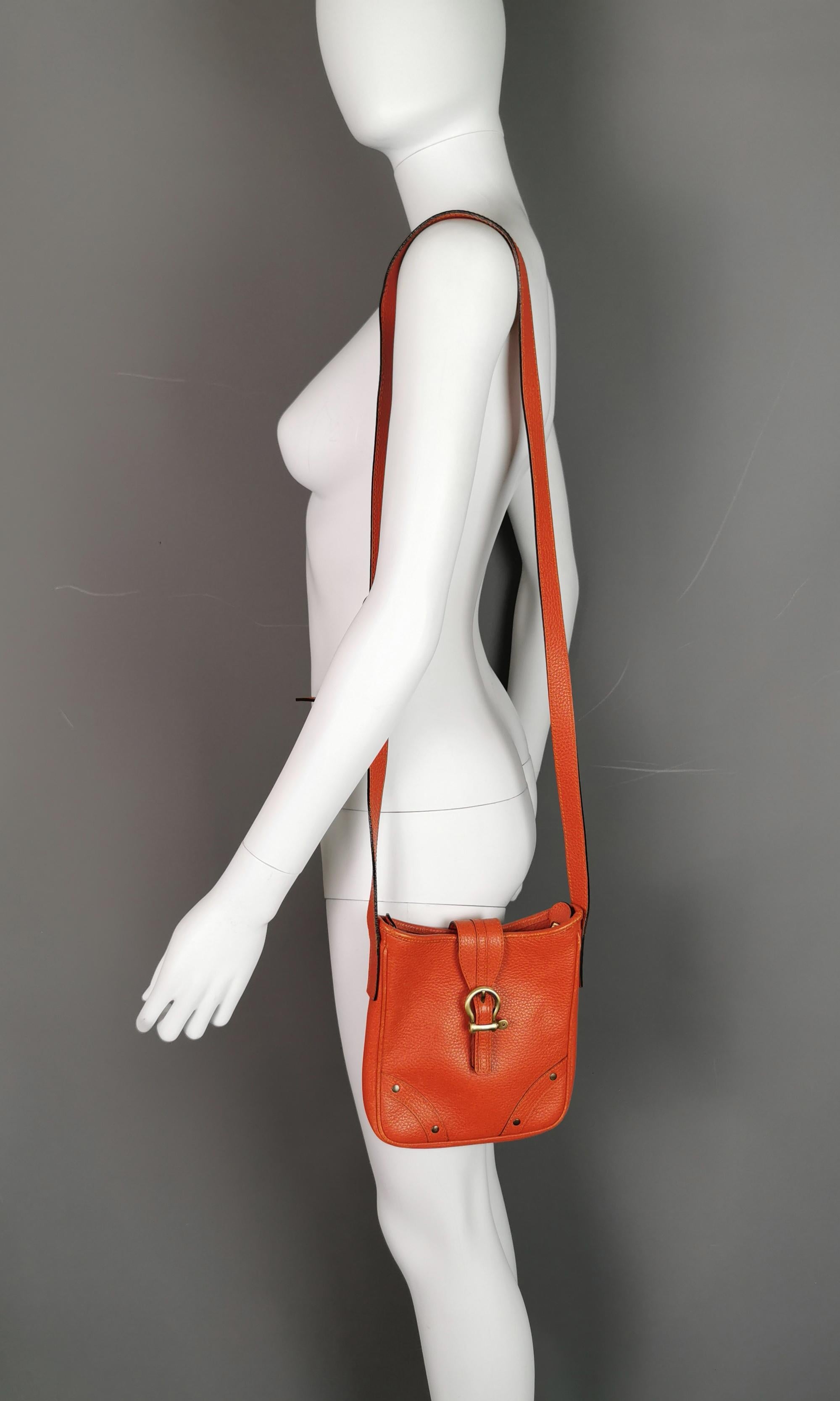 A stylish vintage Burberry orange pebble leather handbag or shoulder bag.

It is a small / medium sized bag, perfect for shopping trips and daily use.

It has lovely supple soft pebble leather in a vibrant juicy orange with signature check canvas