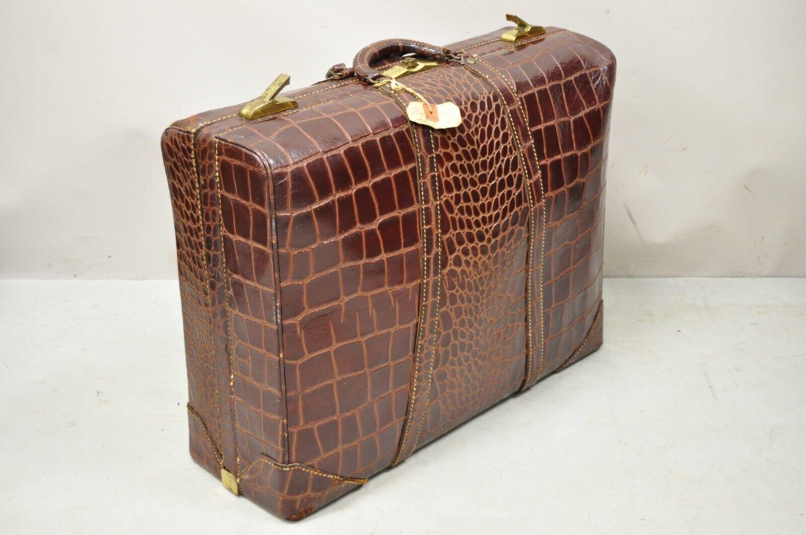 Vintage Burgundy leather Alligator Embossed large Suitcase Luggage bag. Item features multiple interior compartments, alligator embossed burgundy leather, no key, but unlocked. Circa Early 1900s. Measurements: 9