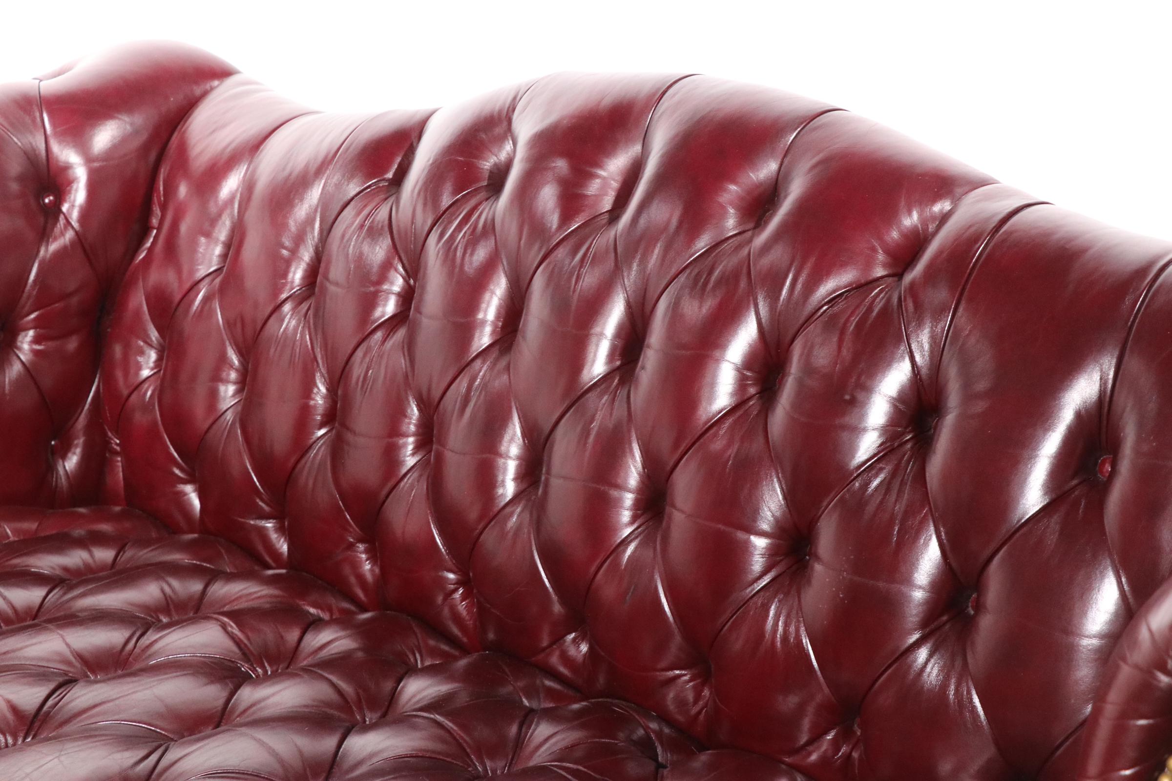 High style Chippendale, Chesterfield sofa having a wood frame, ell construction, with a button tied tufted surface, and brass nail head trim. The sofa in in very fine, original, clean and ready to use condition, from a smoke free, pet free home.