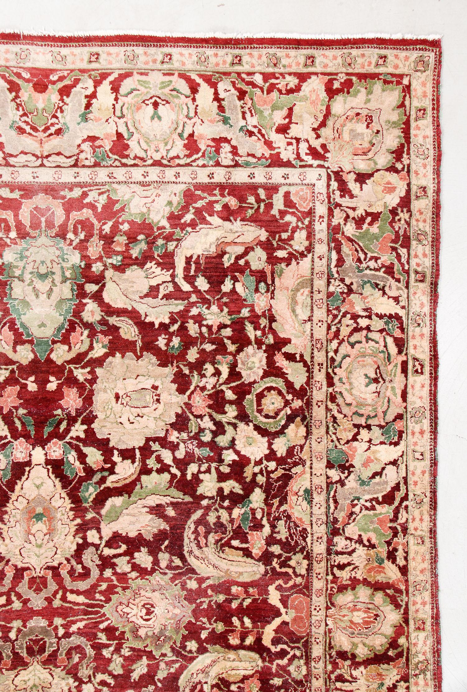 Agra-Teppiche mit burgunderrotem Grund zählen seit jeher zu den raffiniertesten und elegantesten Dekorationsteppichen. Sie wurden während der Kolonialzeit von britischen Adeligen in Auftrag gegeben, um ihre Schlösser und Paläste zu schmücken. Dieses