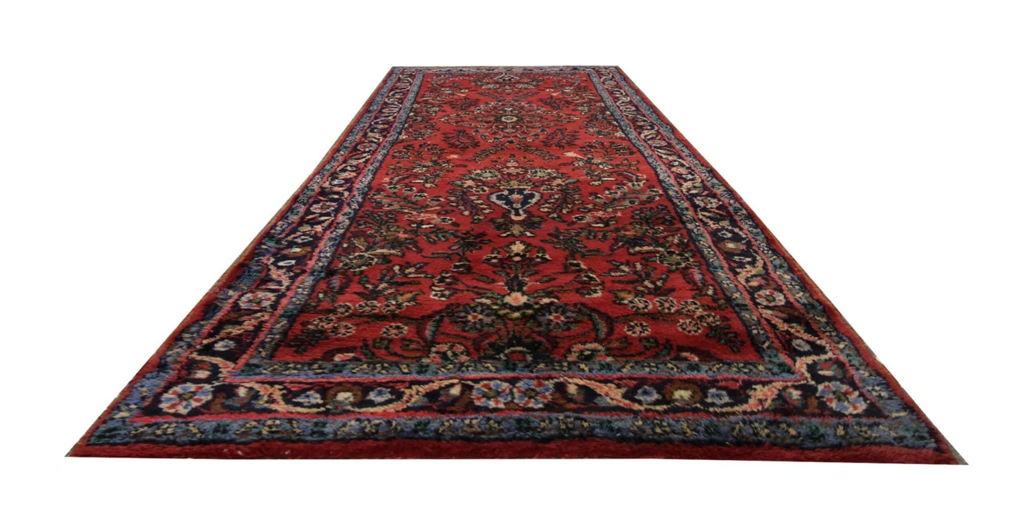 This vintage burgundy red runner rug is hand-knotted with precision and crafted from a blend of wool and cotton, this rug boasts a charming floral design that exudes rustic elegance. Dating back to the 1960s, its vintage allure adds character to any