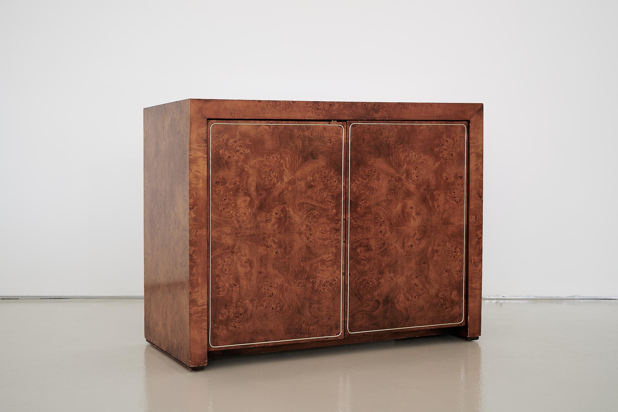 1970’s two-door burl cabinet manufactured by Heckman Furniture

Bird’s eye figure burl veneer stained in a walnut tone warm brown

Thin brass inlay on the doors

Adjustable euro-style hinges

Interior shallow drawer (Heckman stamp on right