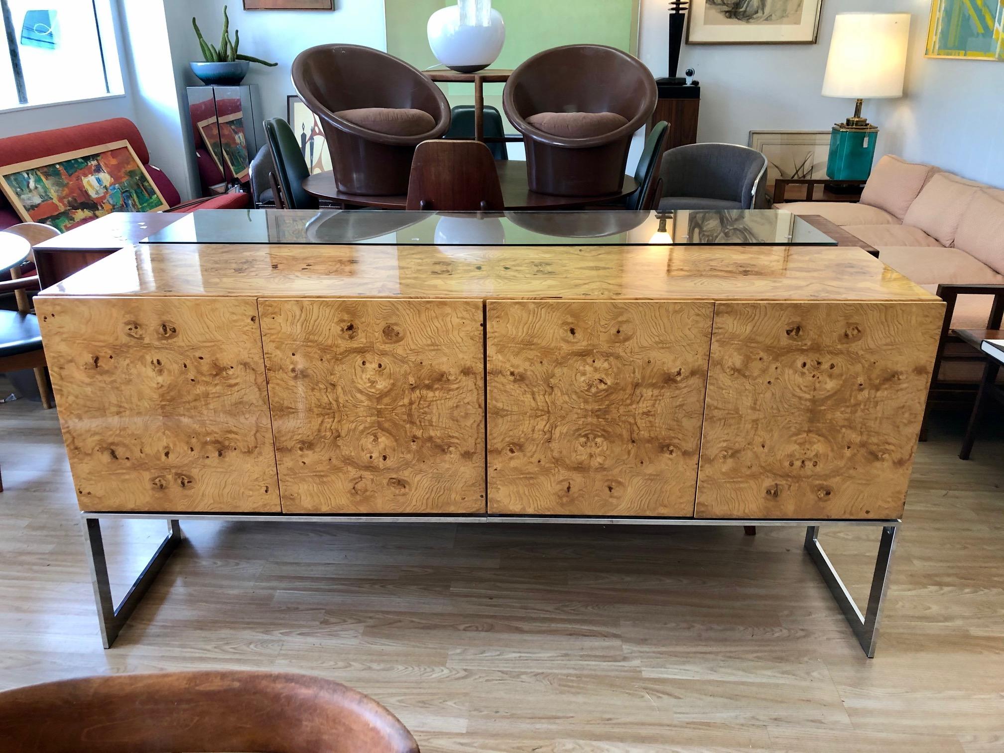 This gorgeous vintage burl wood credenza by Milo Baughman for Thayer Coggin is in overall good condition. Stunning burl wood grain. Glass top. Chrome base. Interior shelving and drawers. Eye-catching statement piece,
circa 1970s.