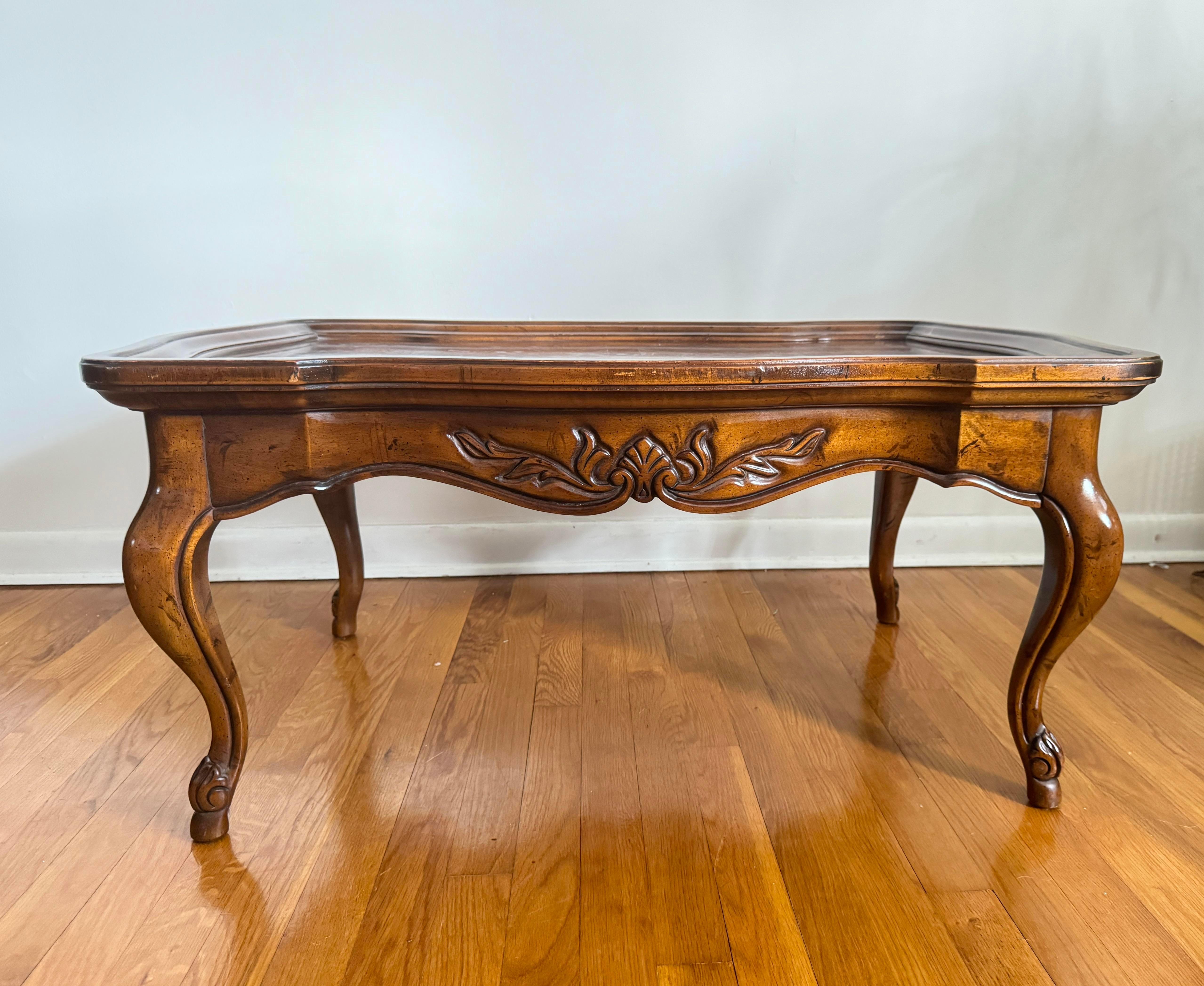 Vintage Burl French Country Coffee Table by Drexel features a beautifully aged burl wood top with intricate grain patterns. Sturdy legs and ornate detailing reflect the classic French country style, making it a perfect blend of rustic charm and