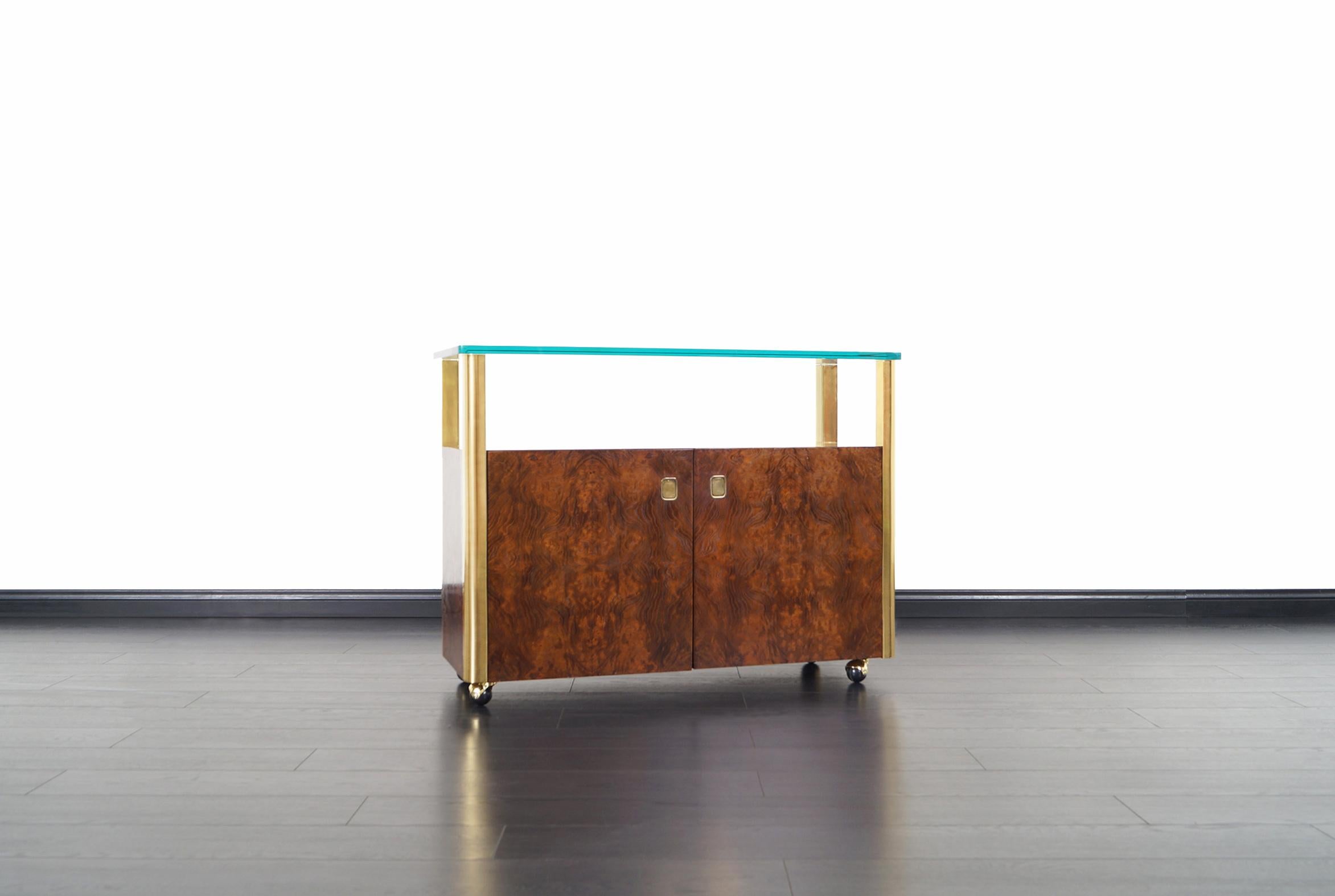 Vintage burl wood and brass bar cart designed and manufactured by Century Furniture Company in the United States, circa 1970s. This fabulous bar car features a thick glass top that sits over four brass columns, and a burl wood cabinet in the center