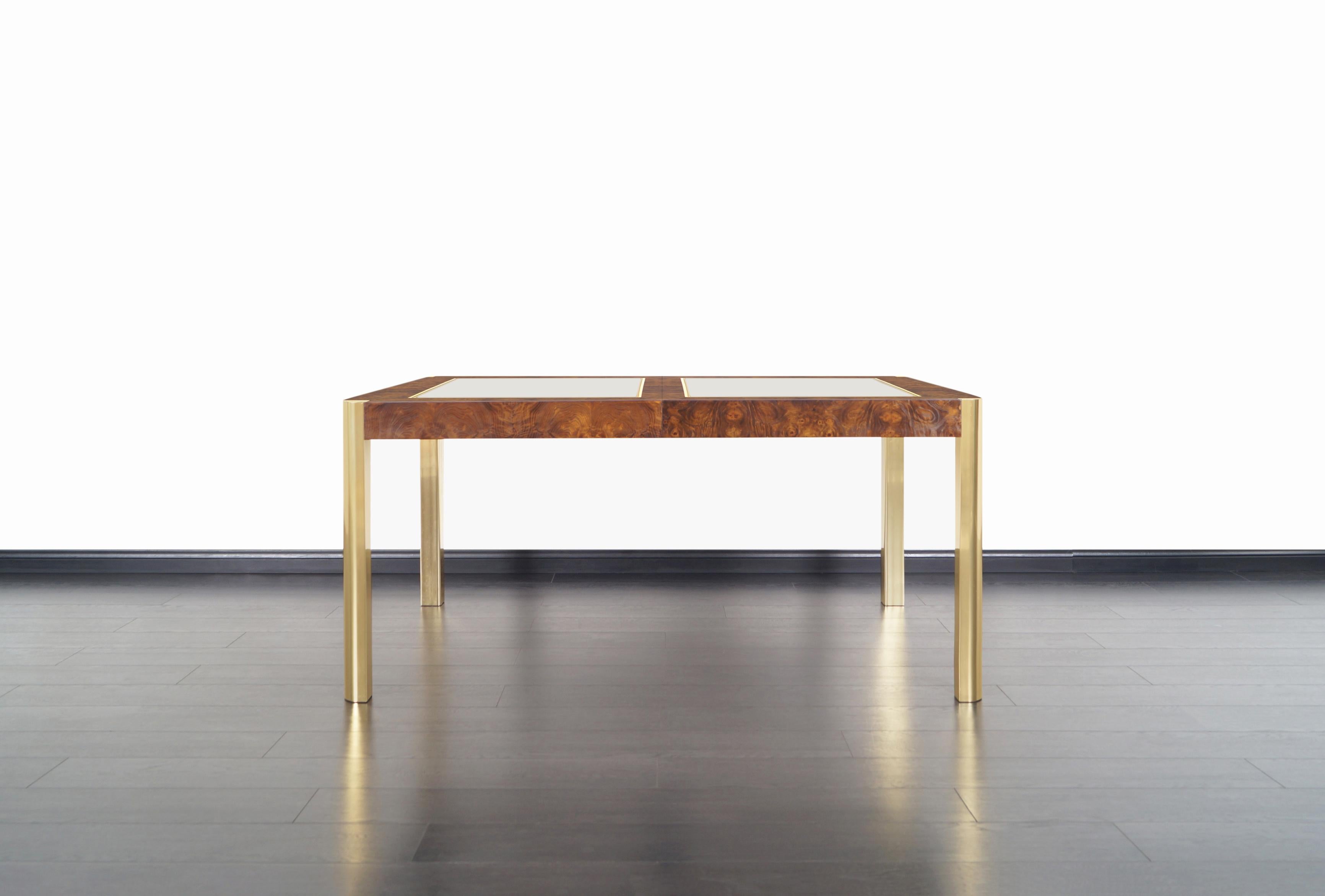 An expanding vintage burl wood and brass dining table manufactured by Century Furniture Company in the United States, circa 1970s. This fabulous dining table comes with two additional 18' leaves. The table measures 96