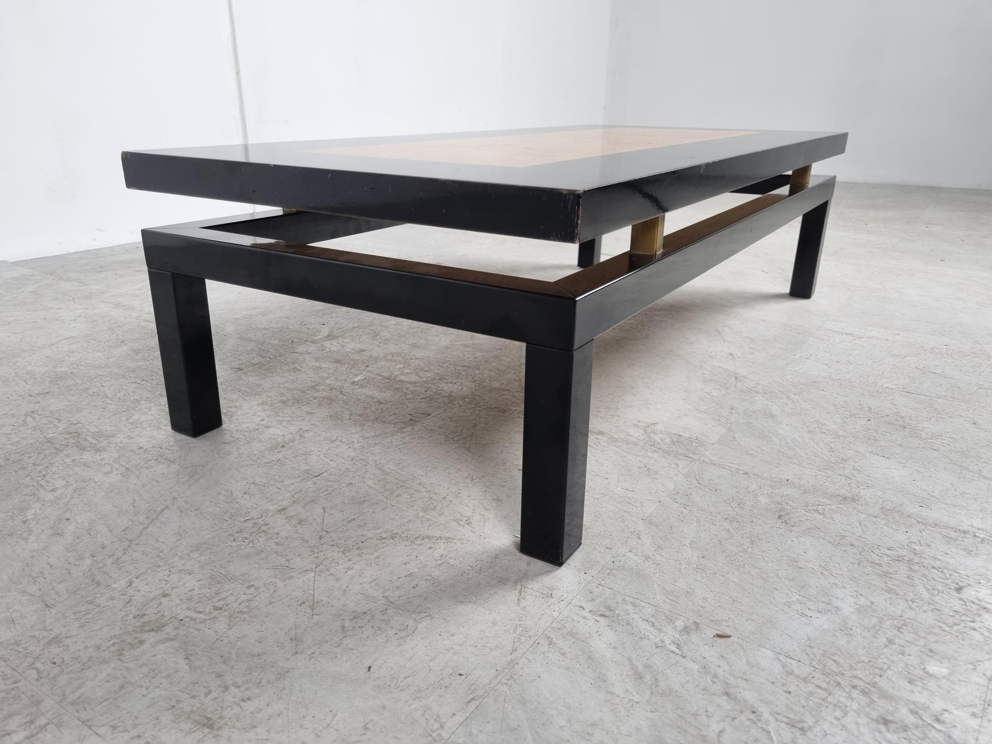 Luxurious looking coffee table with a black lacquered wood frame with an inserted burl wood top and brass.

The table is in the style of Guy Lefevre's design.

Good looking high quality coffee table from the seventies glam period.

1970s -