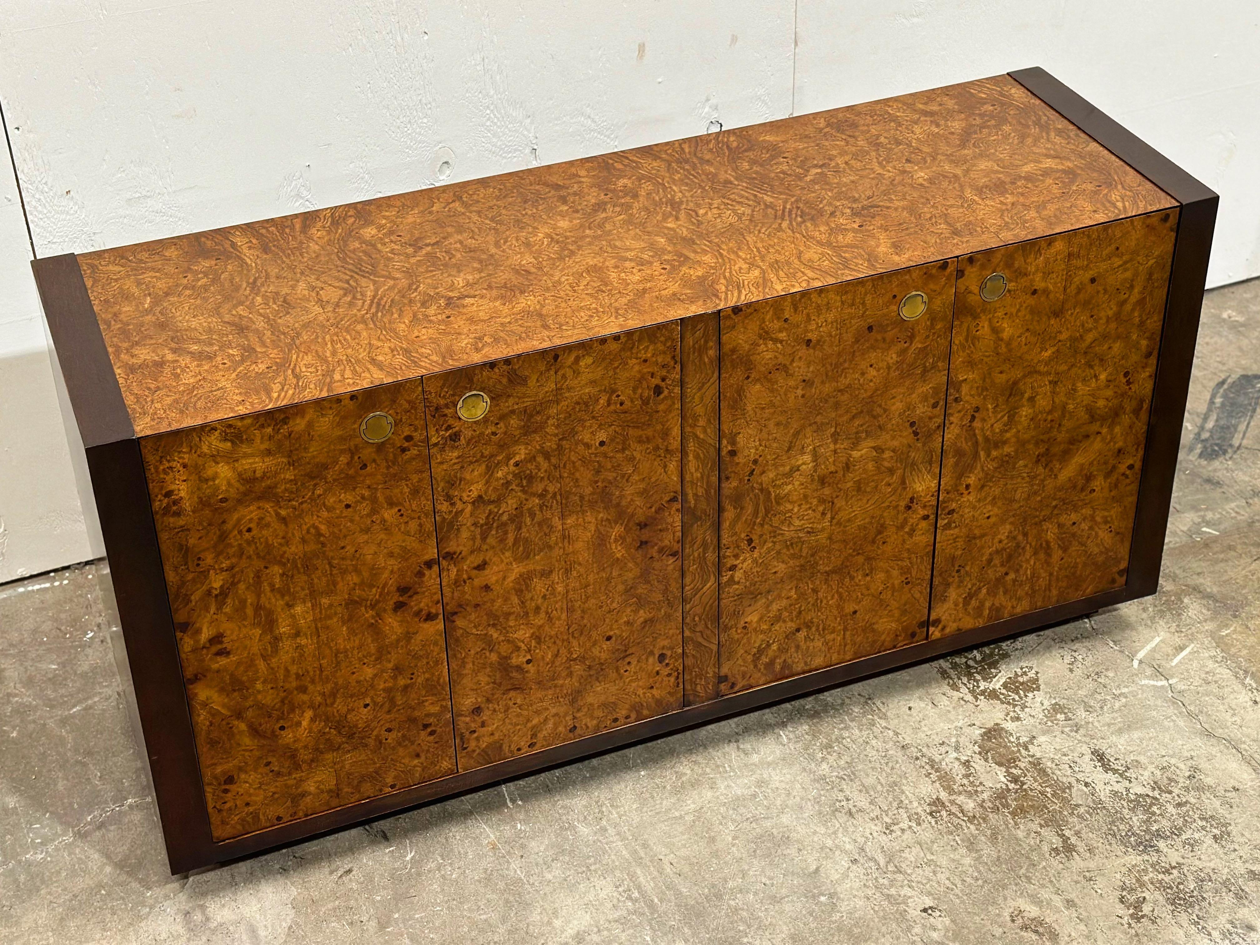 Vintage burled olive wood, mahogany and brass credenza by Century Furniture, circa 1970s.
Recessed solid brass hardware. Doors open to reveal two drawers and shelved storage.
Excellent original condition with minor signs of use. No flaws of note.