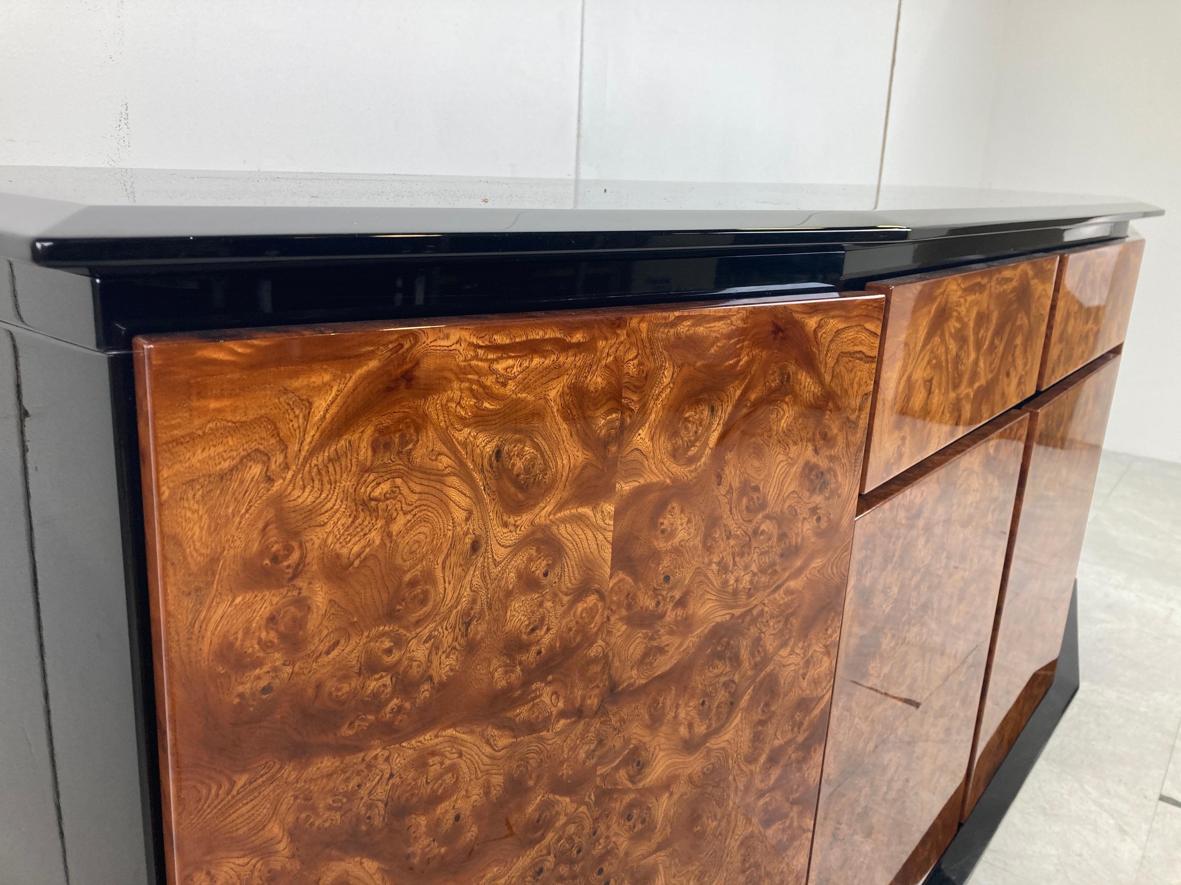High quality burl wood sideboard/credenza.

This piece has been built with very high quality materials like beautiful burl wood veneer and black lacquered wood.

Labeled by Paul Michel.

The sideboard has 4 doors and two drawers.

Good