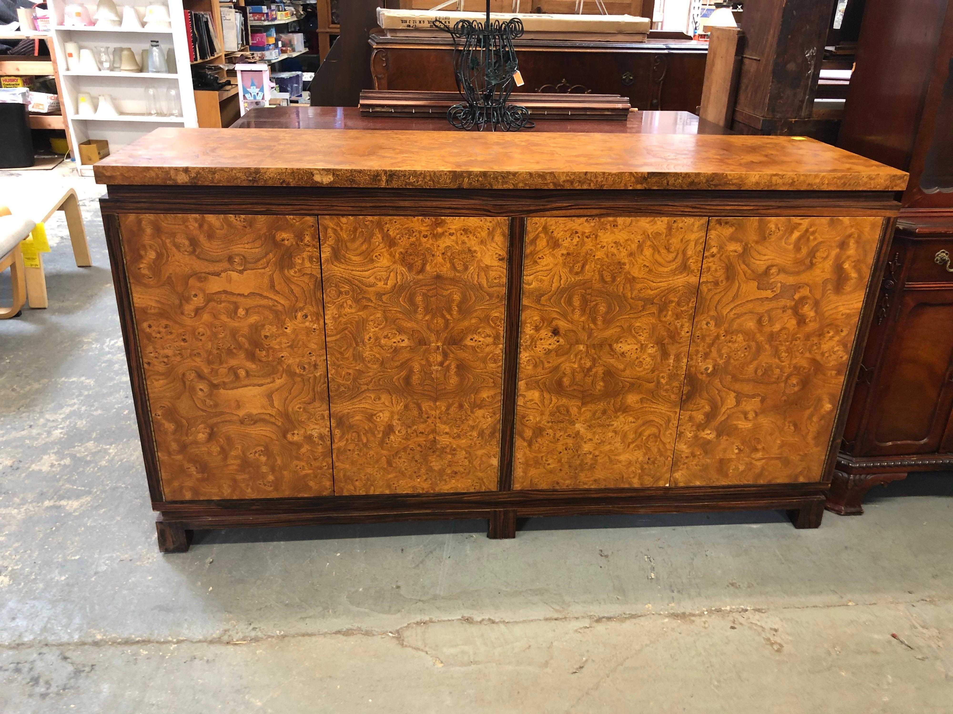 Vintage burlwood credenza with rosewood trim. Elegant Art Deco style piece with great storage. Sophisticated and timeless piece for entertaining. Magnetic doors give off a clean frontal appearance. Simply push to open which reveals adjustable
