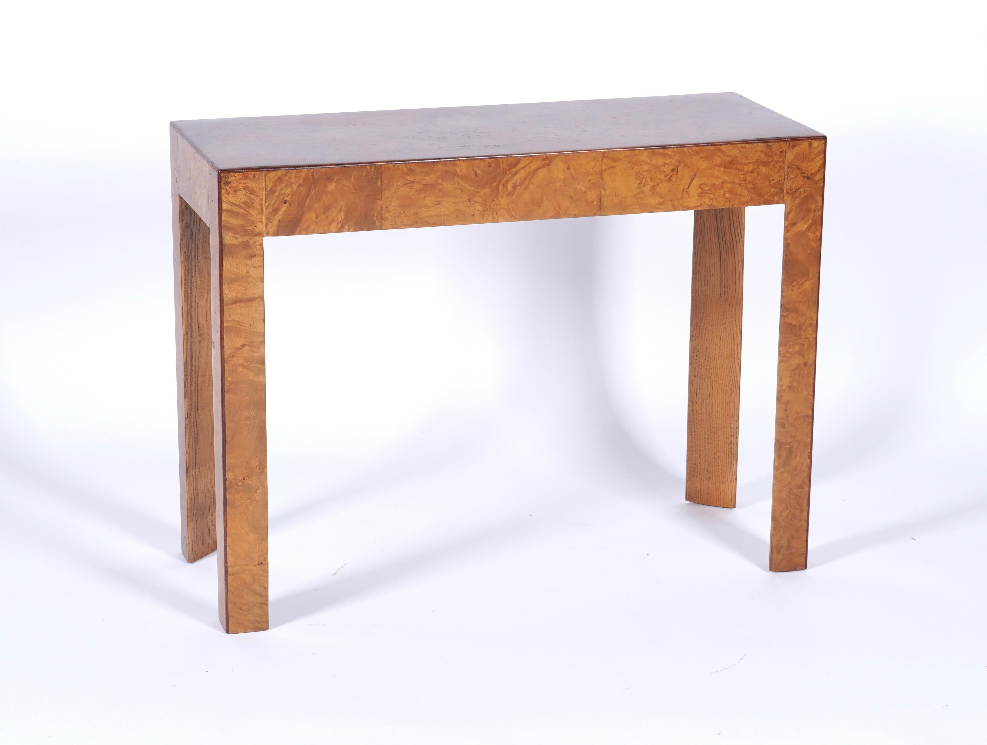 Burl wood console table with a sleek modernist design, figurative burl wood veneer throughout its entire construction. With dark golden honey color to the finish and with the edges trimmed in a dark hardwood to create a nice contrast in the overall