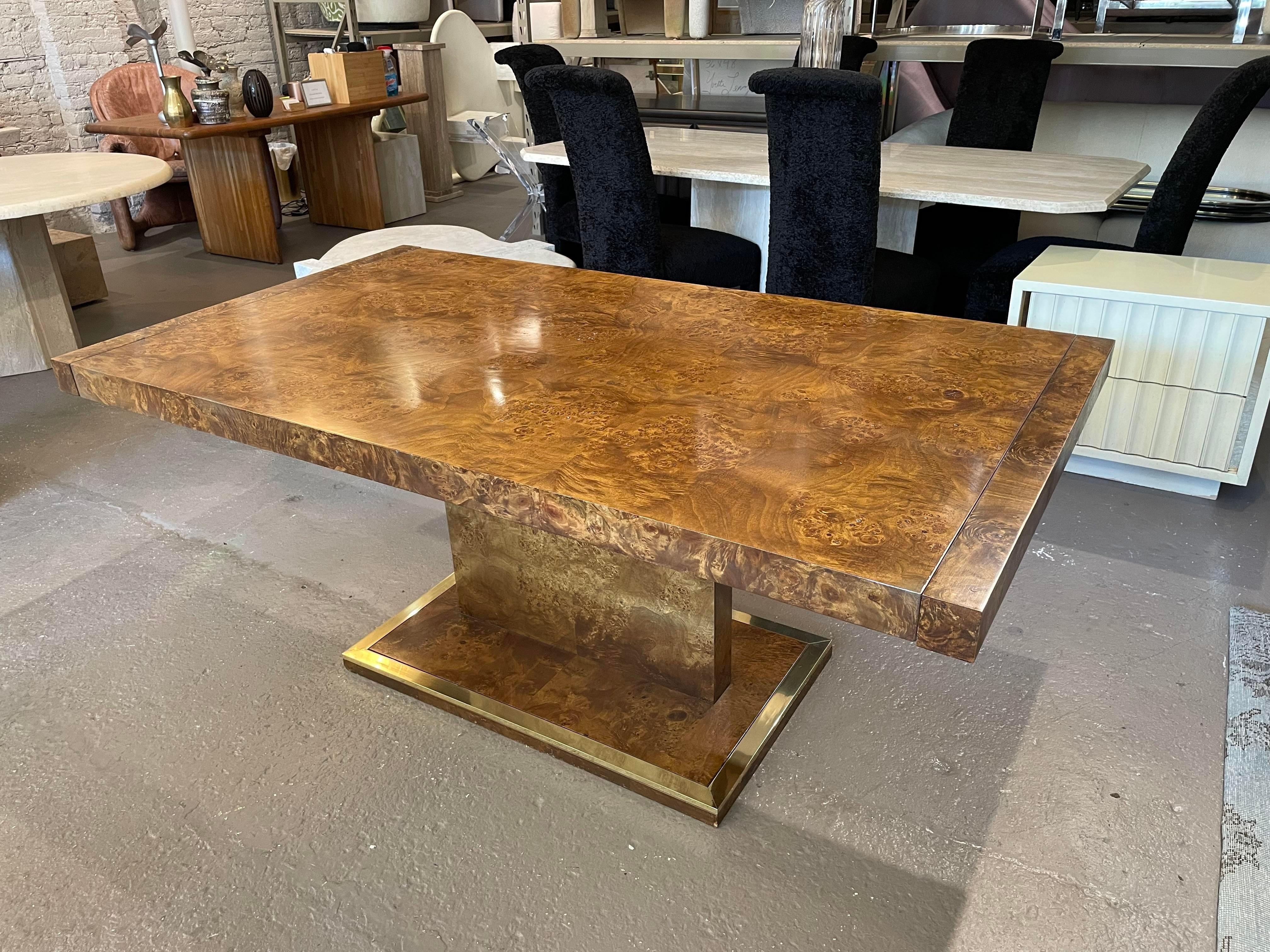 Stunning burled wood and brass extension leaf dining table. This looks like it was never or rarely used. A warm wood color with the slightest amount of brass at the pedestal base makes this a simply dramatic table.

With both leafs in the table is