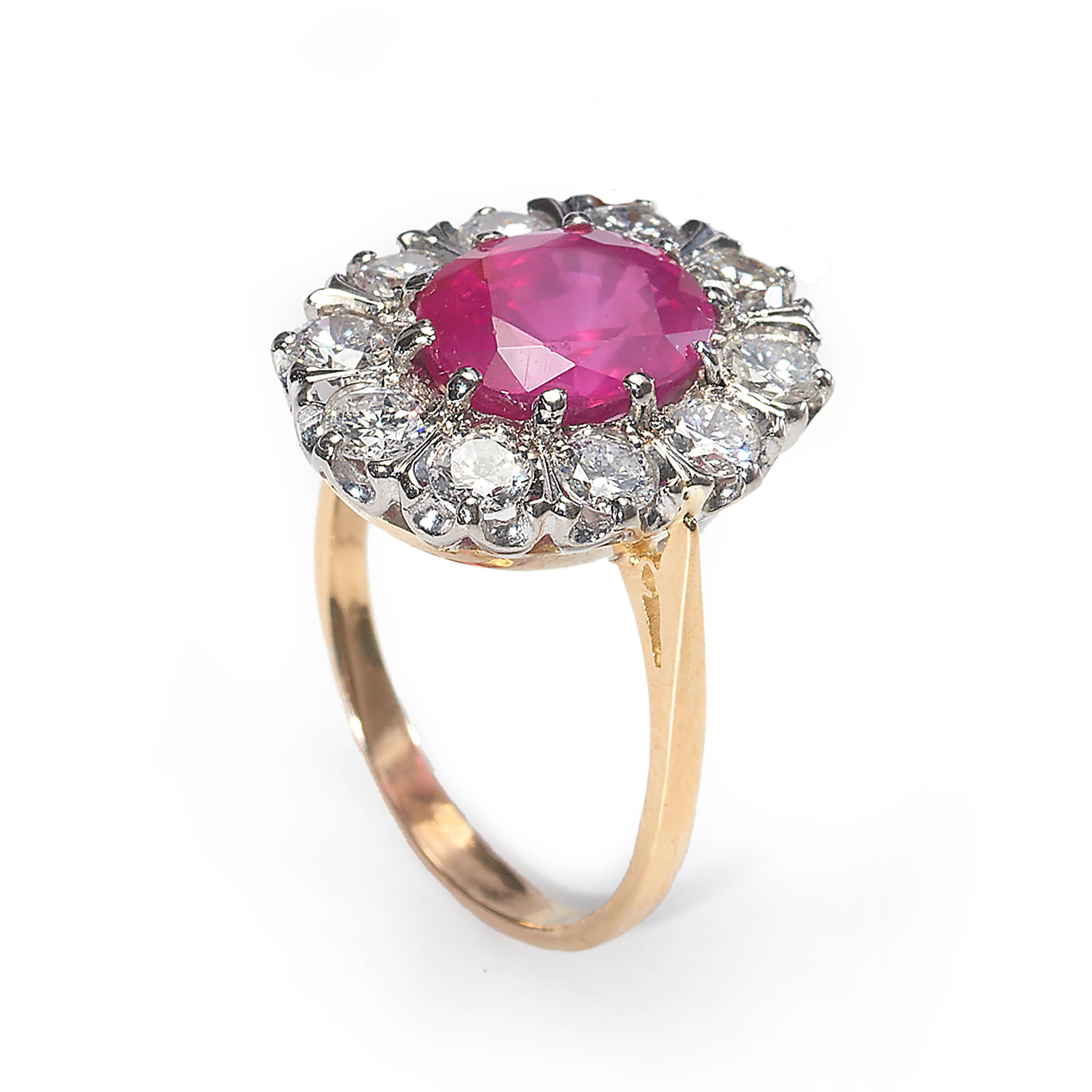 A vintage cluster ring, set with an oval-cut Burmese ruby to the centre, weighing 4.33 carats, surrounded by ten round brilliant-cut diamonds, mounted in 18ct yellow and white gold. Hallmarked London 1979.

With a ruby report from The Gem & Pearl