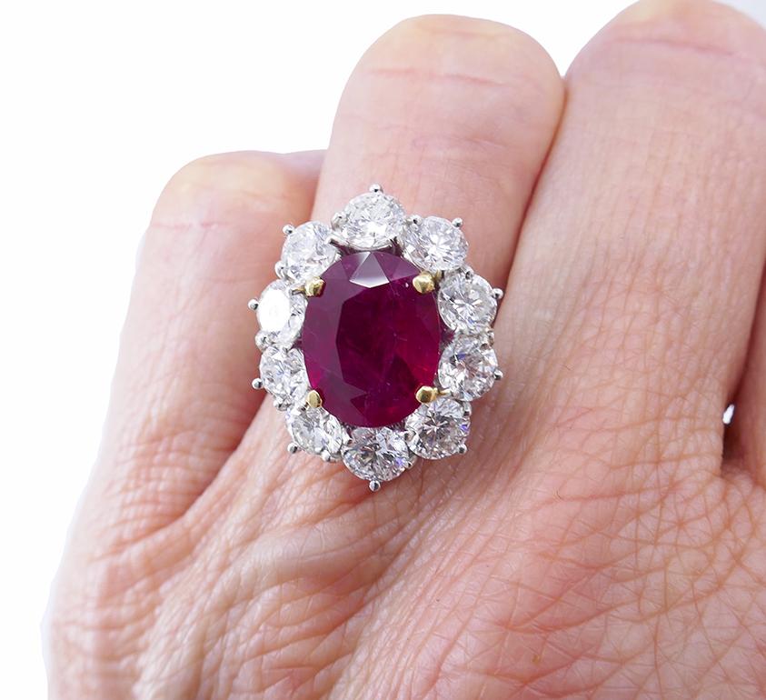 A classic vintage ruby and diamond cluster ring made of 14k white gold. 
The gorgeous Burma ruby in the center is surrounded by ten round brilliant cut diamonds.
The unbeatable white and red combo magnifies the allure of both gemstones. The ruby has