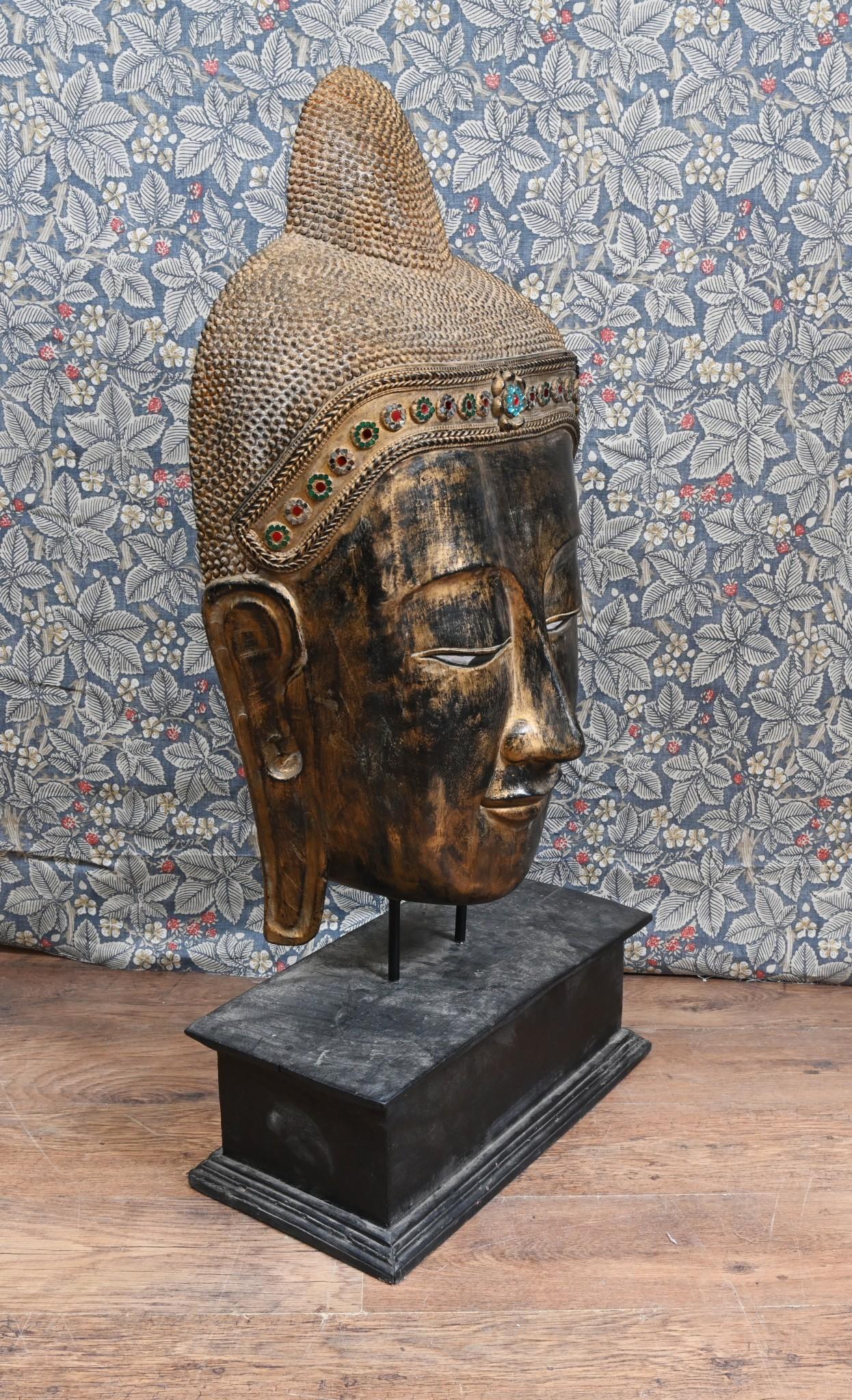 Estudio tallado en madera con acabado dorado de una cabeza de buda birmano en excelente estado de conservación
Este busto está montado sobre un soporte o base oblonga de madera
Alrededor de 1930
Presenta bolas de cristal de colores incrustadas en la