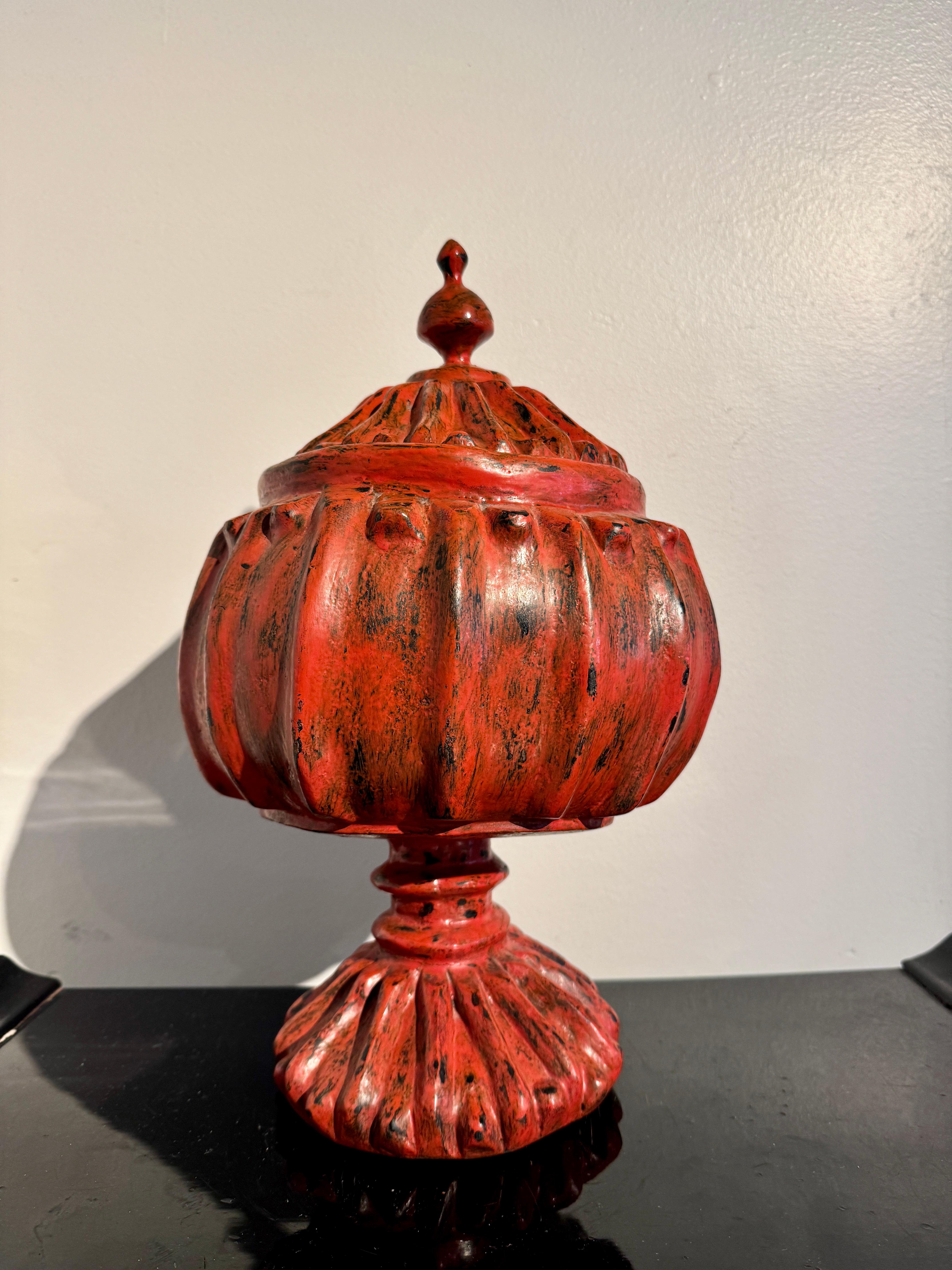 Vase à lotus et couvercle en bois sculpté et laqué rouge de Birmanie, milieu du 20e siècle, Birmanie (Myanmar), attrayant et très décoratif. 

Le récipient est de forme A, avec un grand corps sphérique reposant sur une base haute et étroite avec un