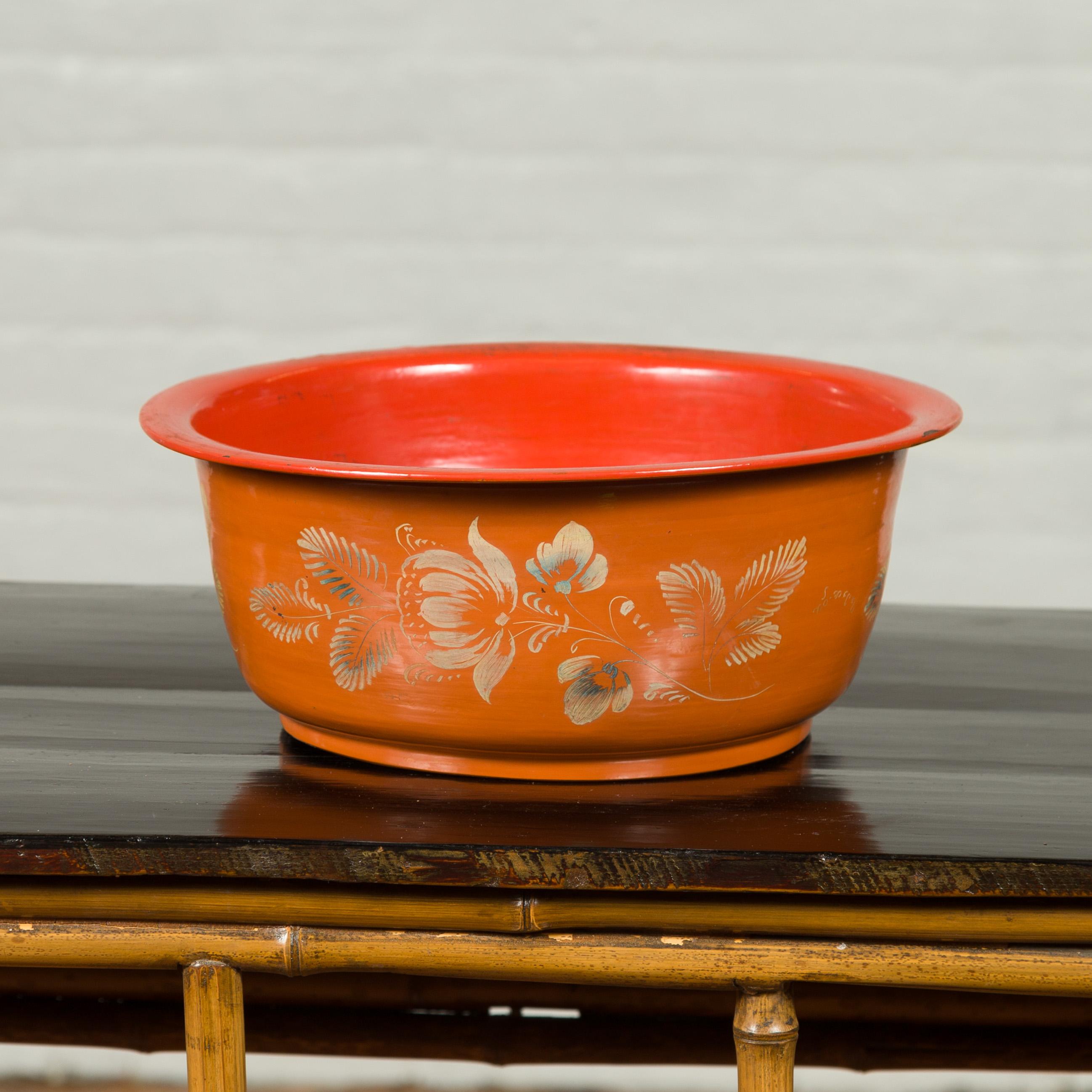 A Burmese vintage lacquered papier mâché bowl from the mid-20th century with floral design. Created in Burma during the midcentury period, this simple papier mâché bowl attracts our attention with its orange and red tones, delicately accented with