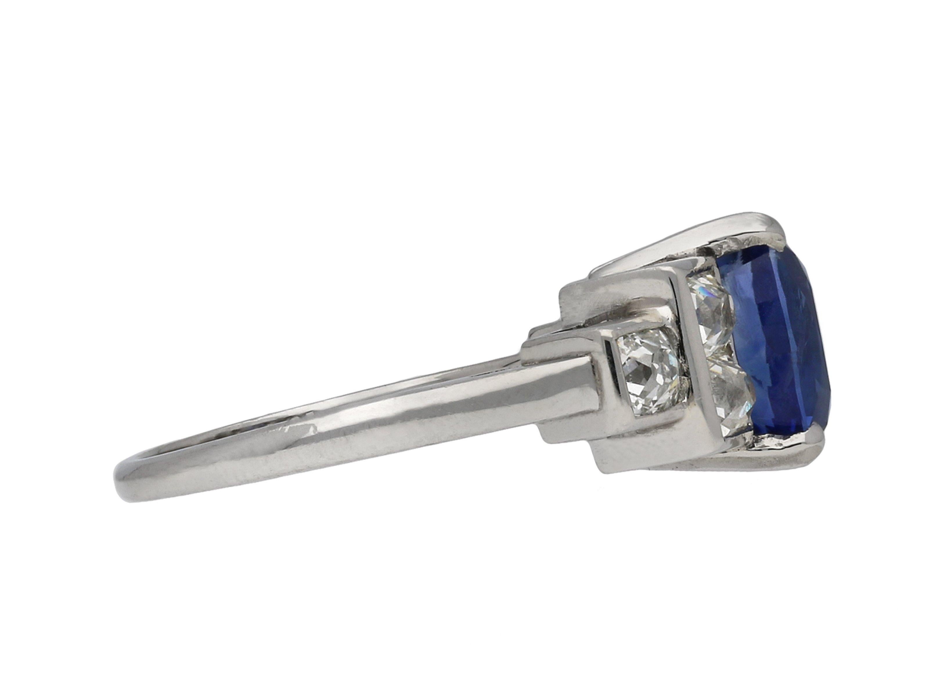 Vintage Burmese sapphire and diamond ring. Set to centre with an oval old cut Burmese sapphire in an open back claw setting with an approximate weight of 4.45 carats, flanked by six cushion shape old mine cut diamonds in open back rubover settings