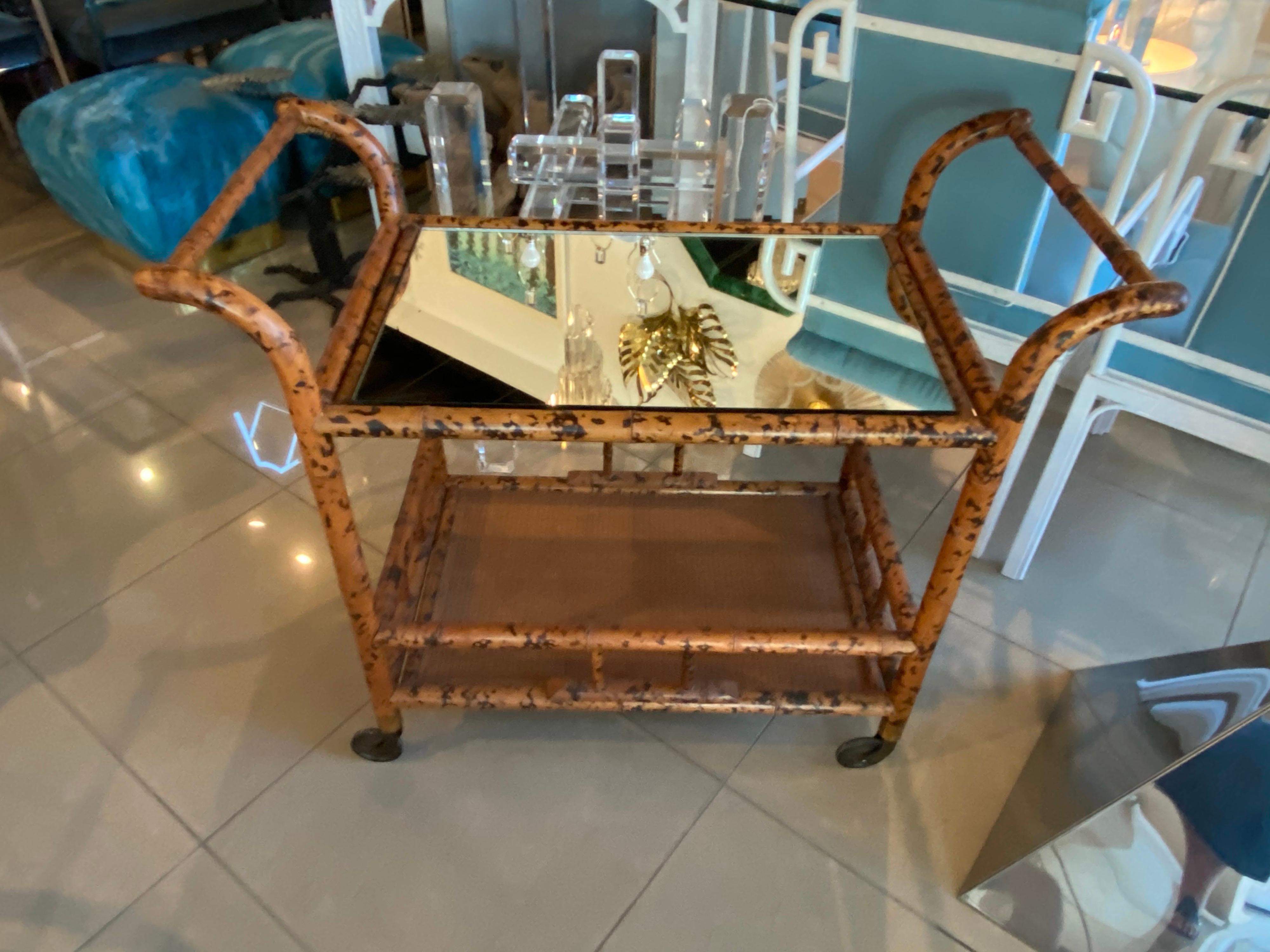 Vintage burnt bamboo bar cart with wheels. New mirror on top shelf. 
 