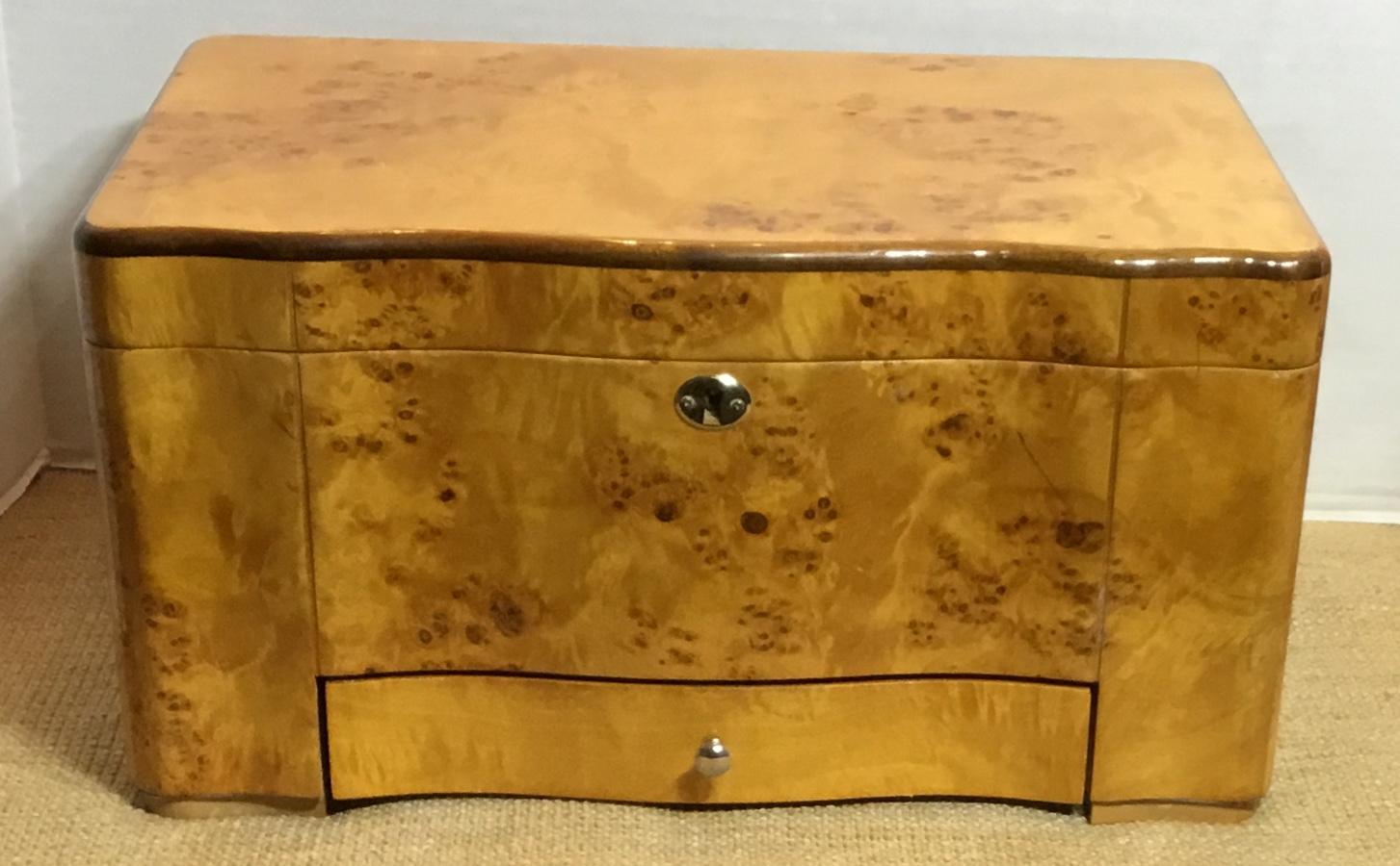 A Classic burr elm humidor made of cedar-lined interior with three compartments, heavy top cover
to keep in the aroma of the cigars in, and equipped with mounted instrument to measuring humidity.
Brass trimming, key is not included.