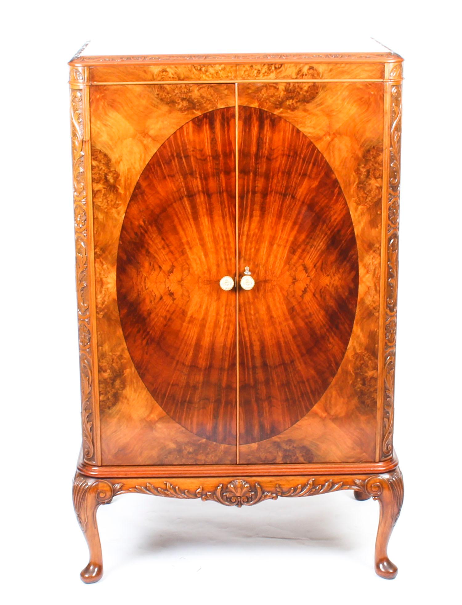 This fantastic vintage 1950s burr walnut cocktail cabinet with the original cut glass ware bears the label of the World renowned retailer, Harrods Ltd London, and dates from the mid-20th century.
 
The beautifully figured burr walnut cabinet has a