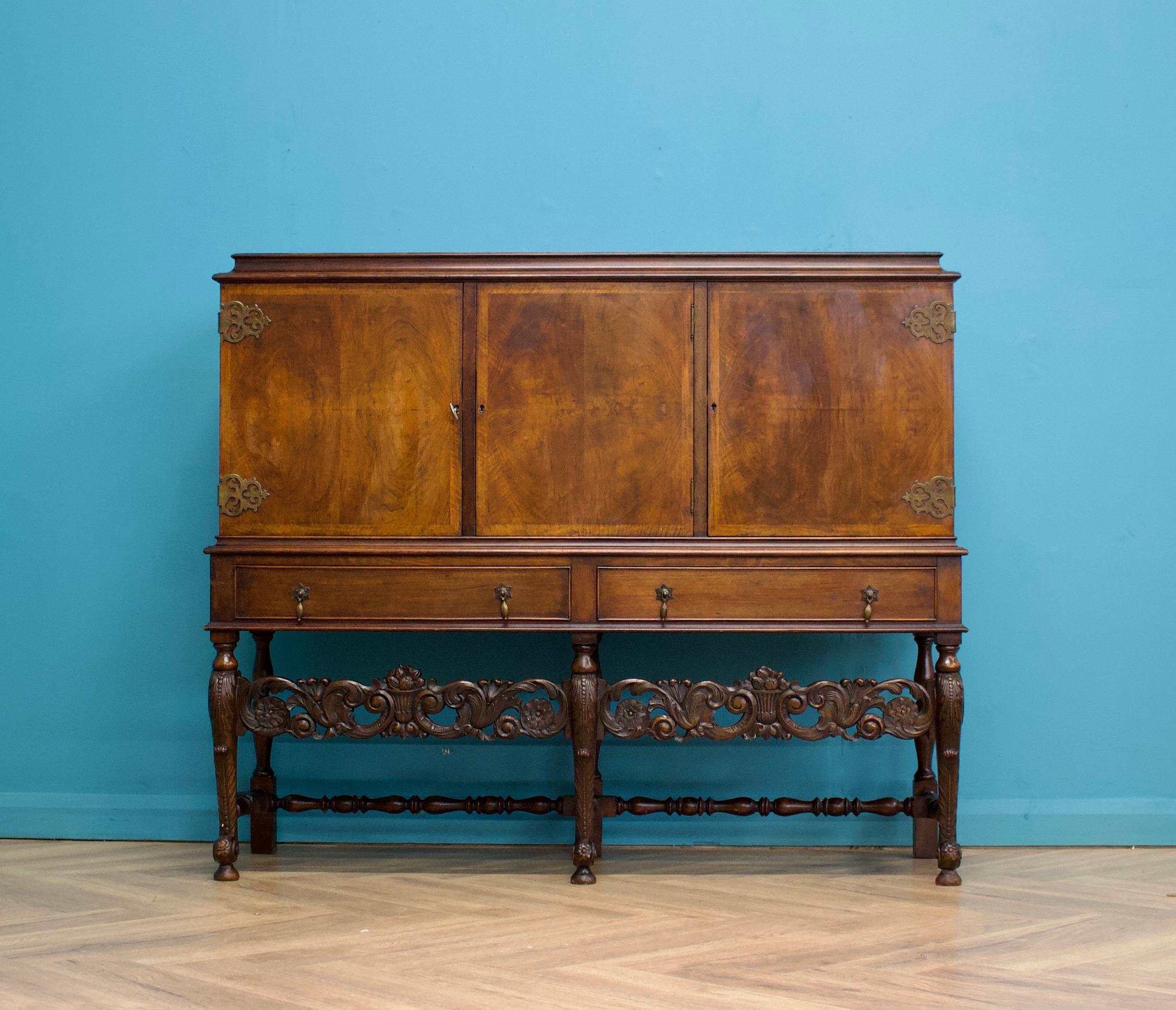 A quality vintage burr walnut antique style drinks cabinet - possibly French or Belgian

Standing on beautifully carved legs

Featuring three cupboards with shelves and three drawers

The three locks work, the key is used as a handle to open each