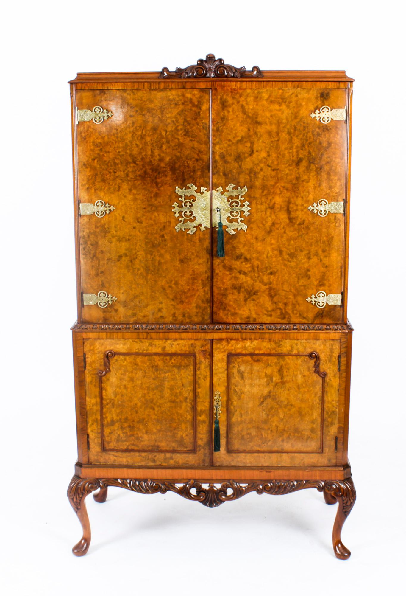 This is a fantastic vintage Epstein style burr walnut cocktail cabinet with fitted and mirrored interior, ormolu mounts, dating from the mid 20th Century.

The upper part comprises a pair of doors that open to reveal a striking fitted mirrored and