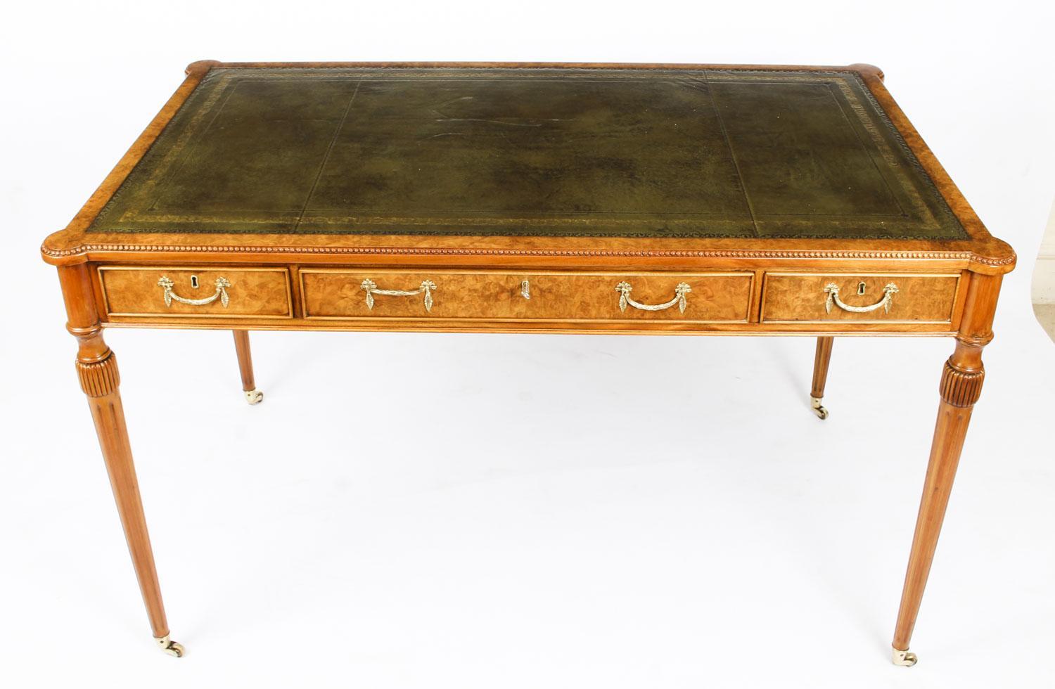 This is an elegant vintage burr walnut writing table reminiscent of the Gillows style and dating from the last quarter of the 20th Century.

This gorgeous desk is crafted from the most beautiful burr walnut and features an inset gold tooled green